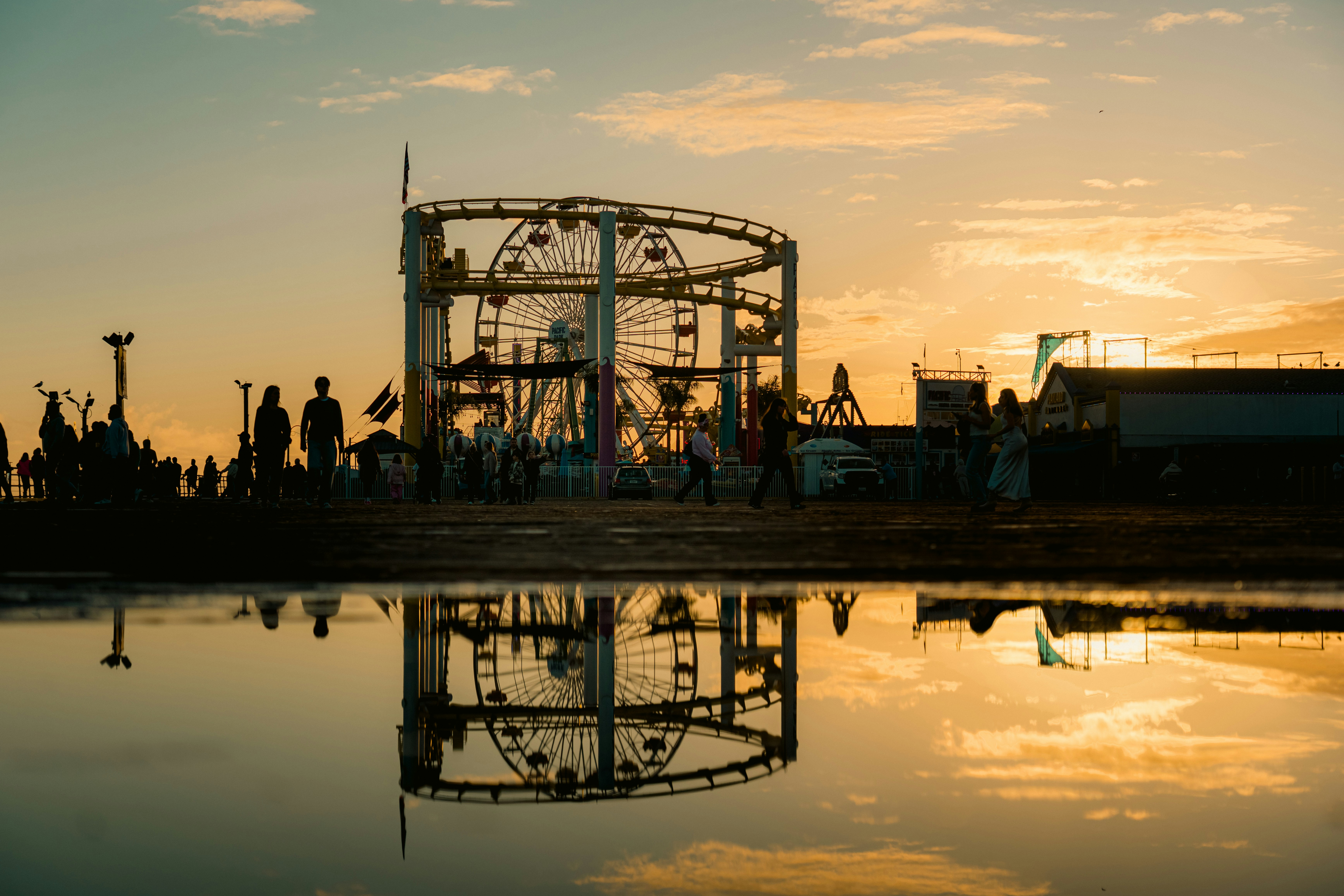 Amusement park rides silhouetted against a sunset sky