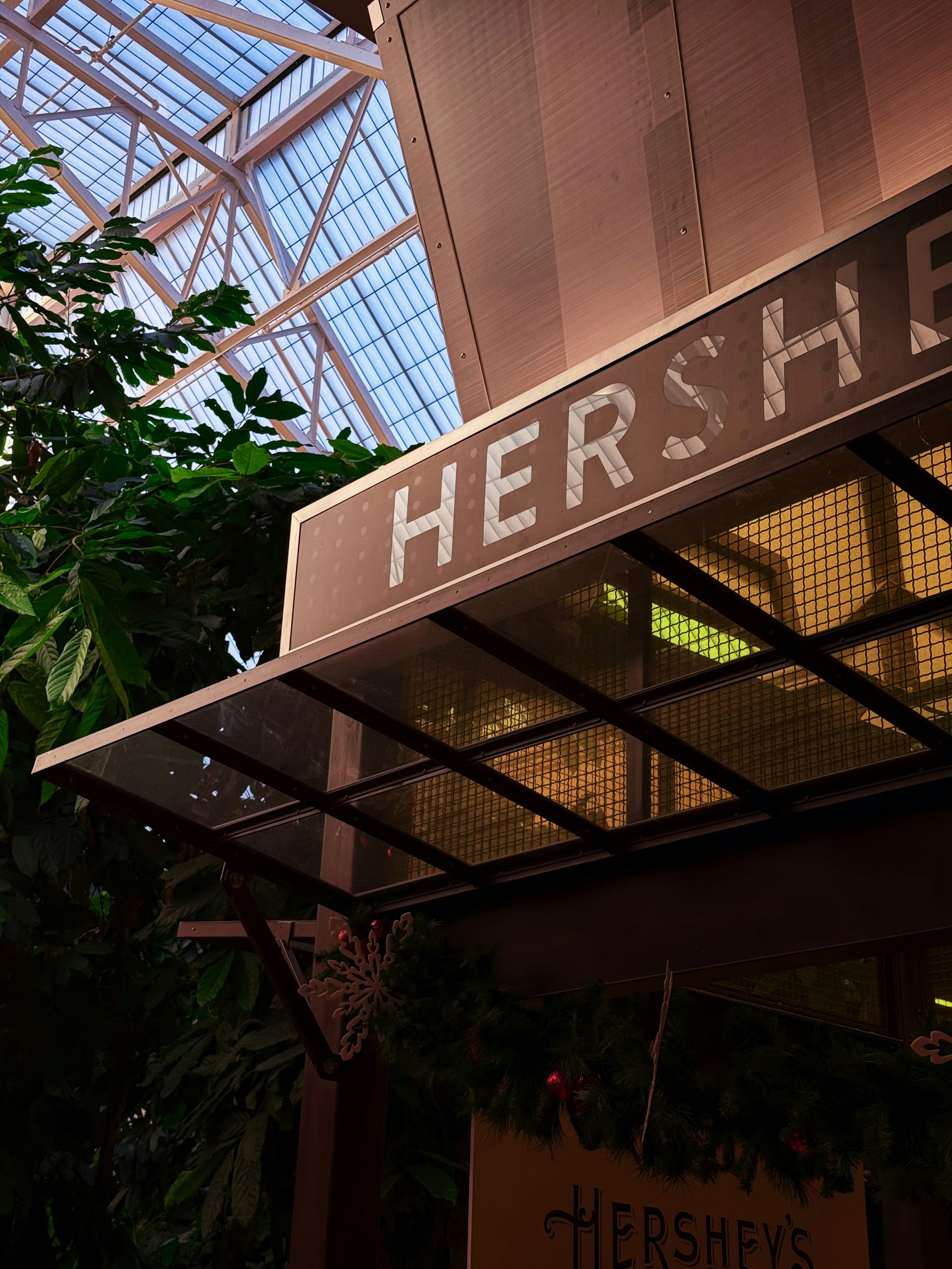 Hershey's sign with greenery and glass ceiling.