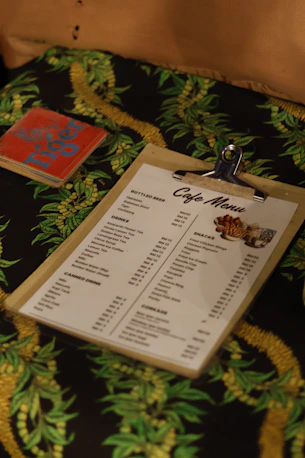 Cafe menu on a clipboard with a book
