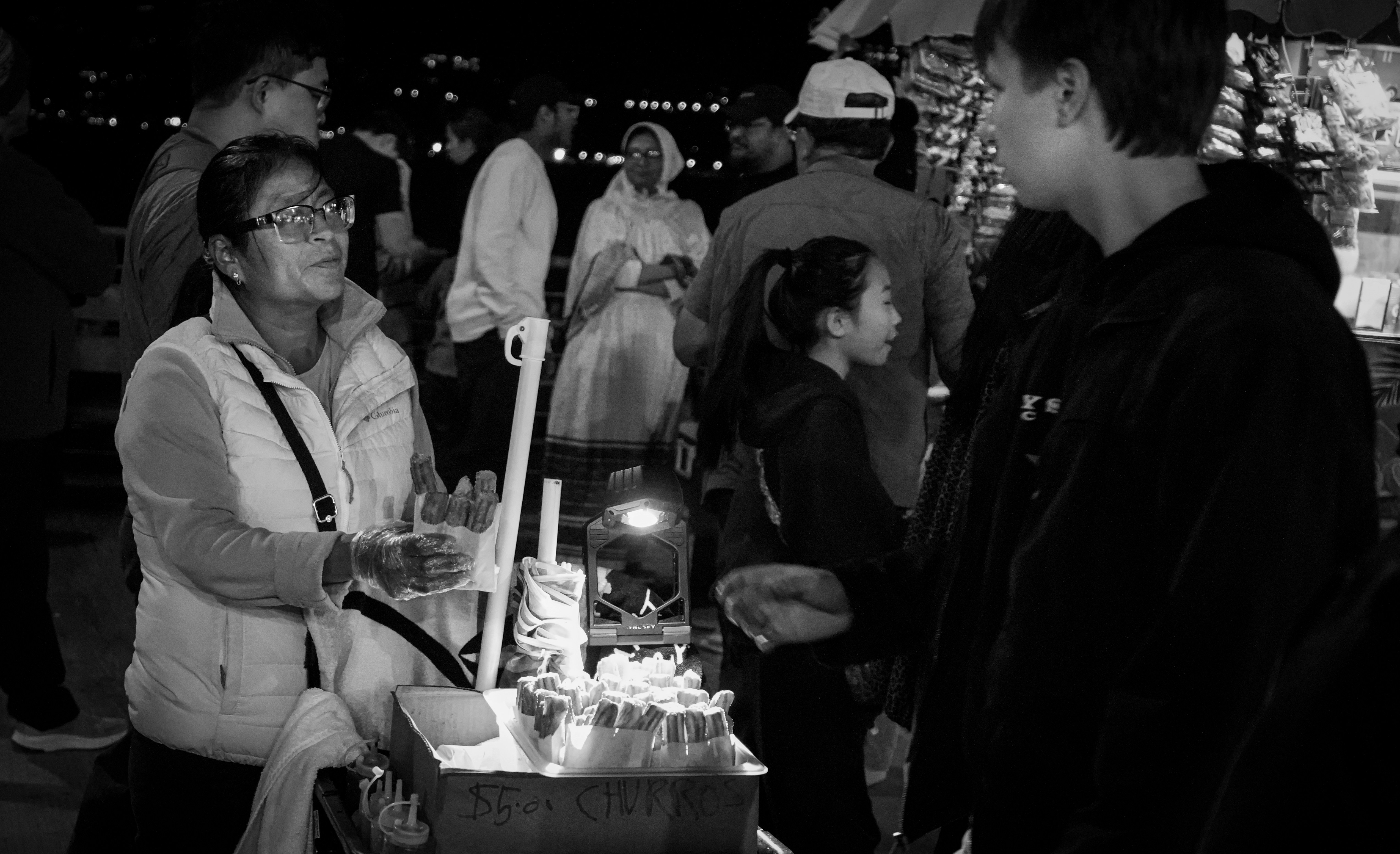 La gente si radunava attorno a un venditore ambulante di notte.