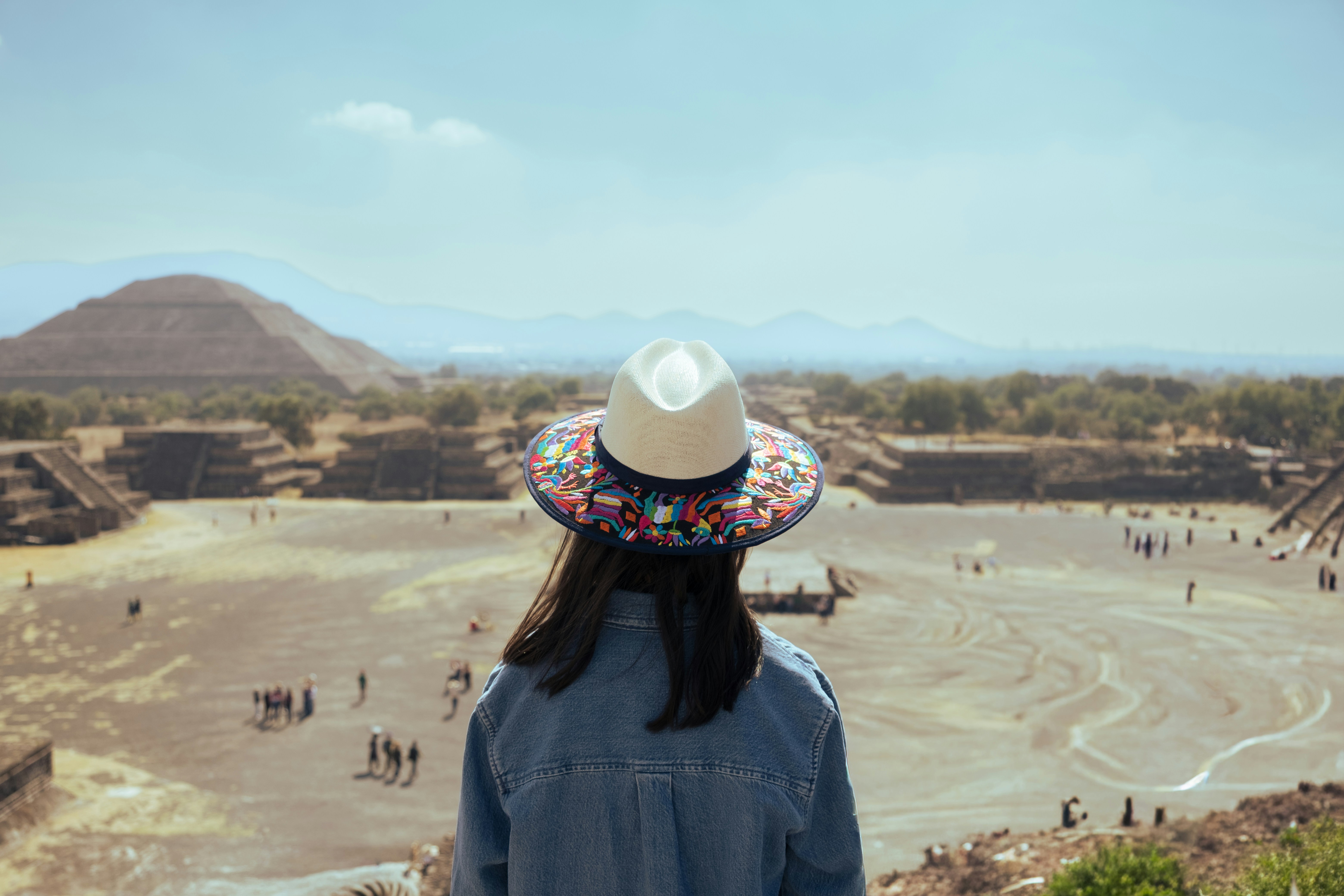 Femme au chapeau regardant des ruines antiques