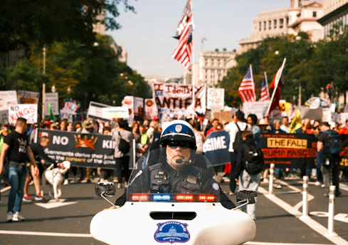 Police officer on motorcycle leads protest march with flags