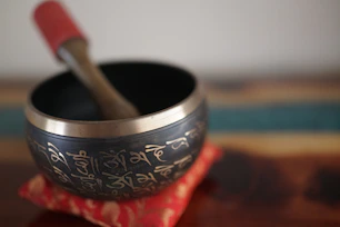 Tibetan singing bowl with wooden striker on cushion
