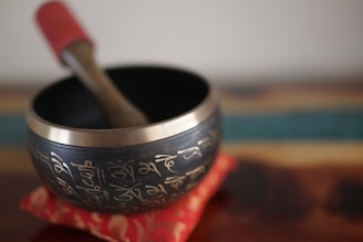Tibetan singing bowl with wooden striker on cushion