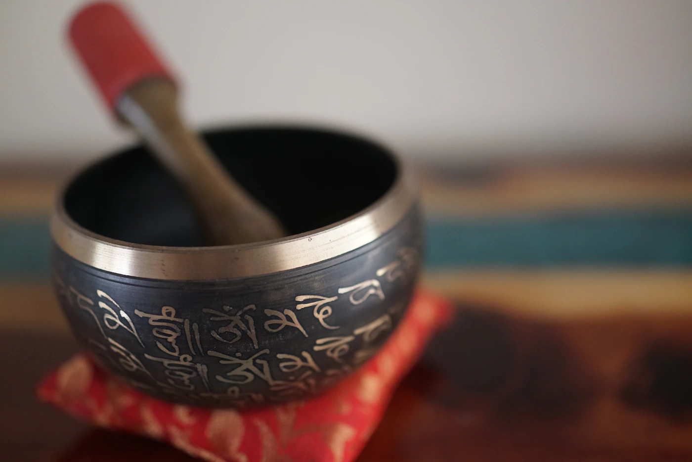 Cuenco tibetano y percutor de madera sobre un cojín