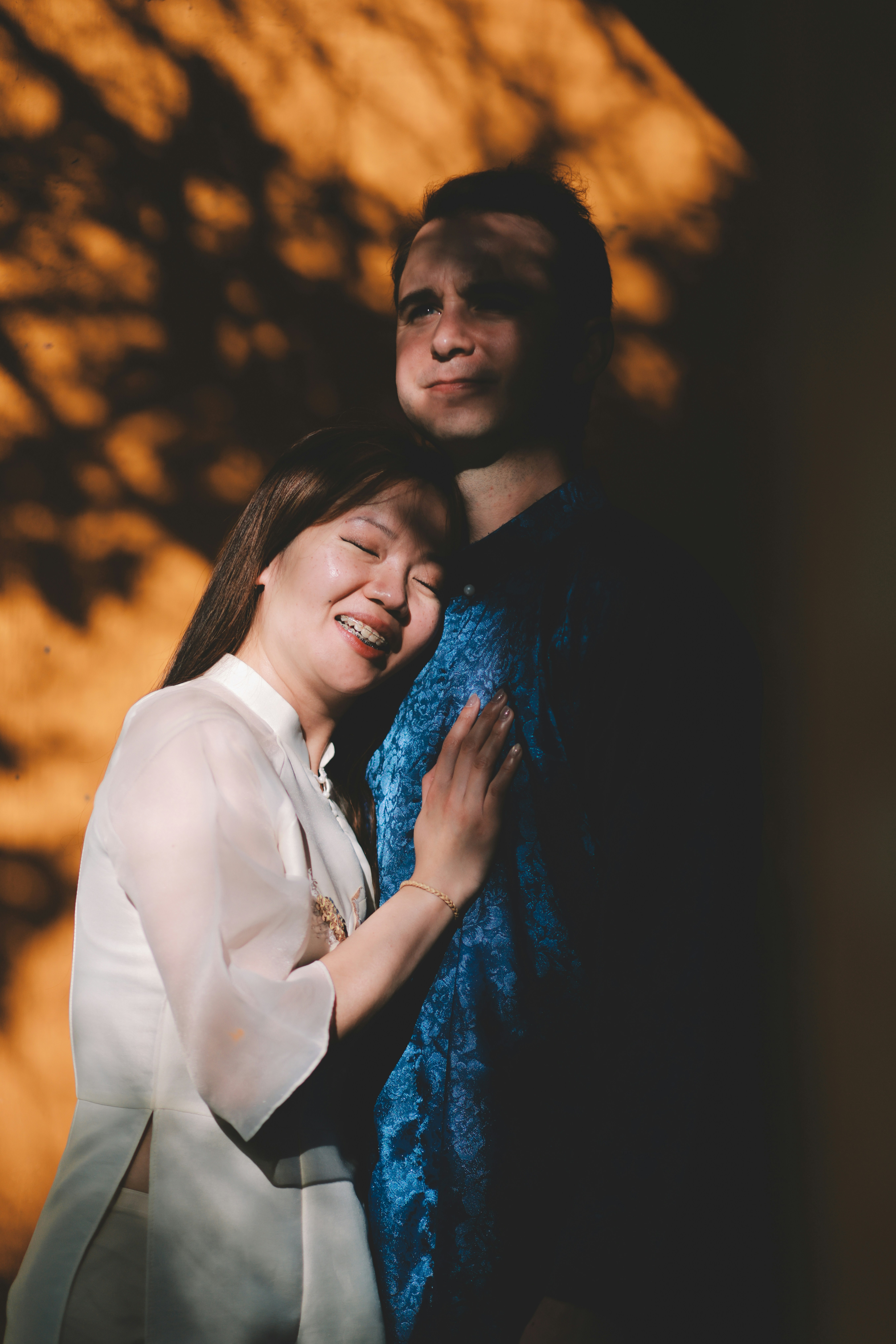 A couple embracing in dappled sunlight