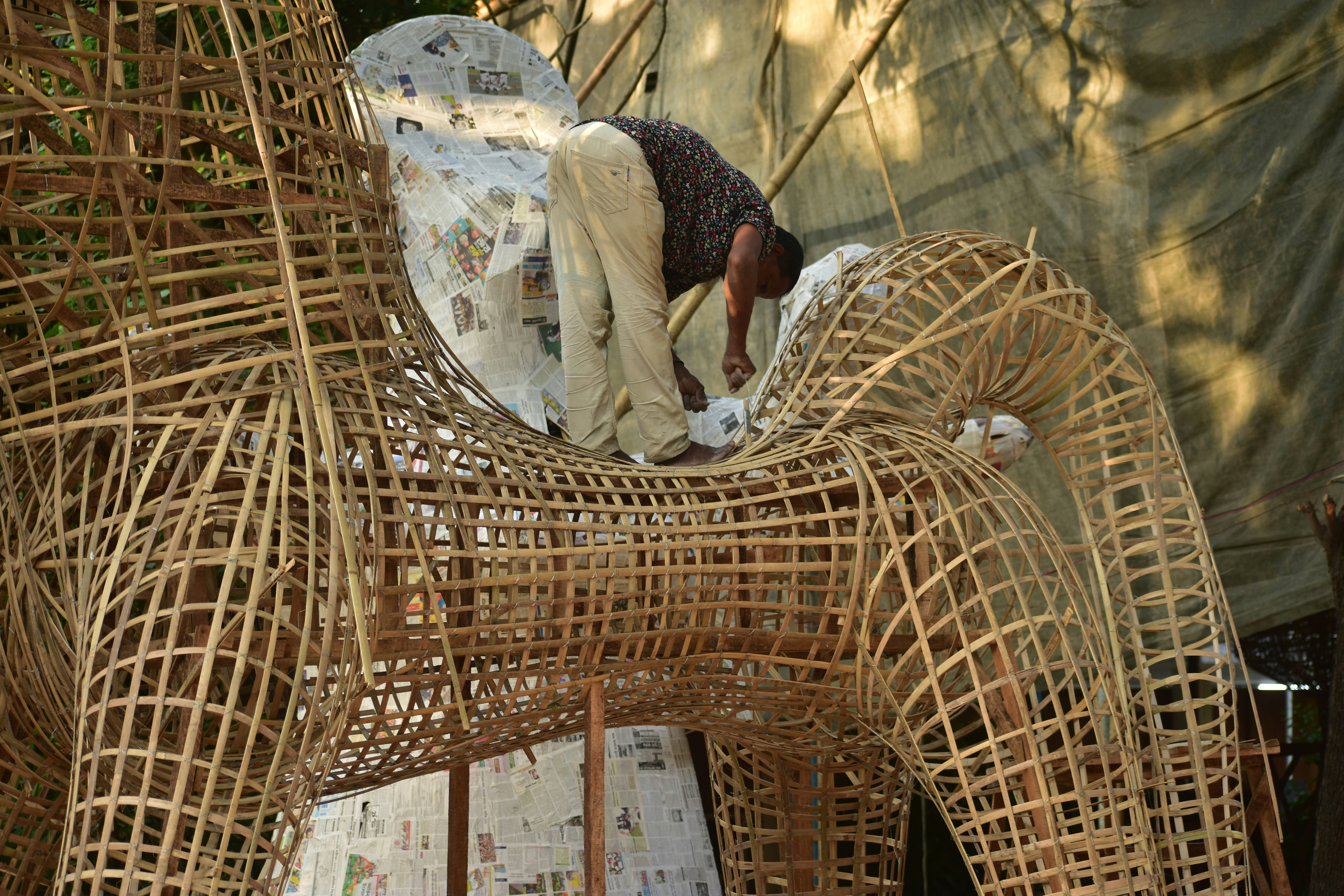 Person working on a large wicker horse structure