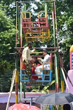 People riding a colorful ferris wheel at an outdoor fair.