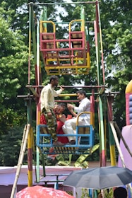 People riding a colorful ferris wheel at an outdoor fair.