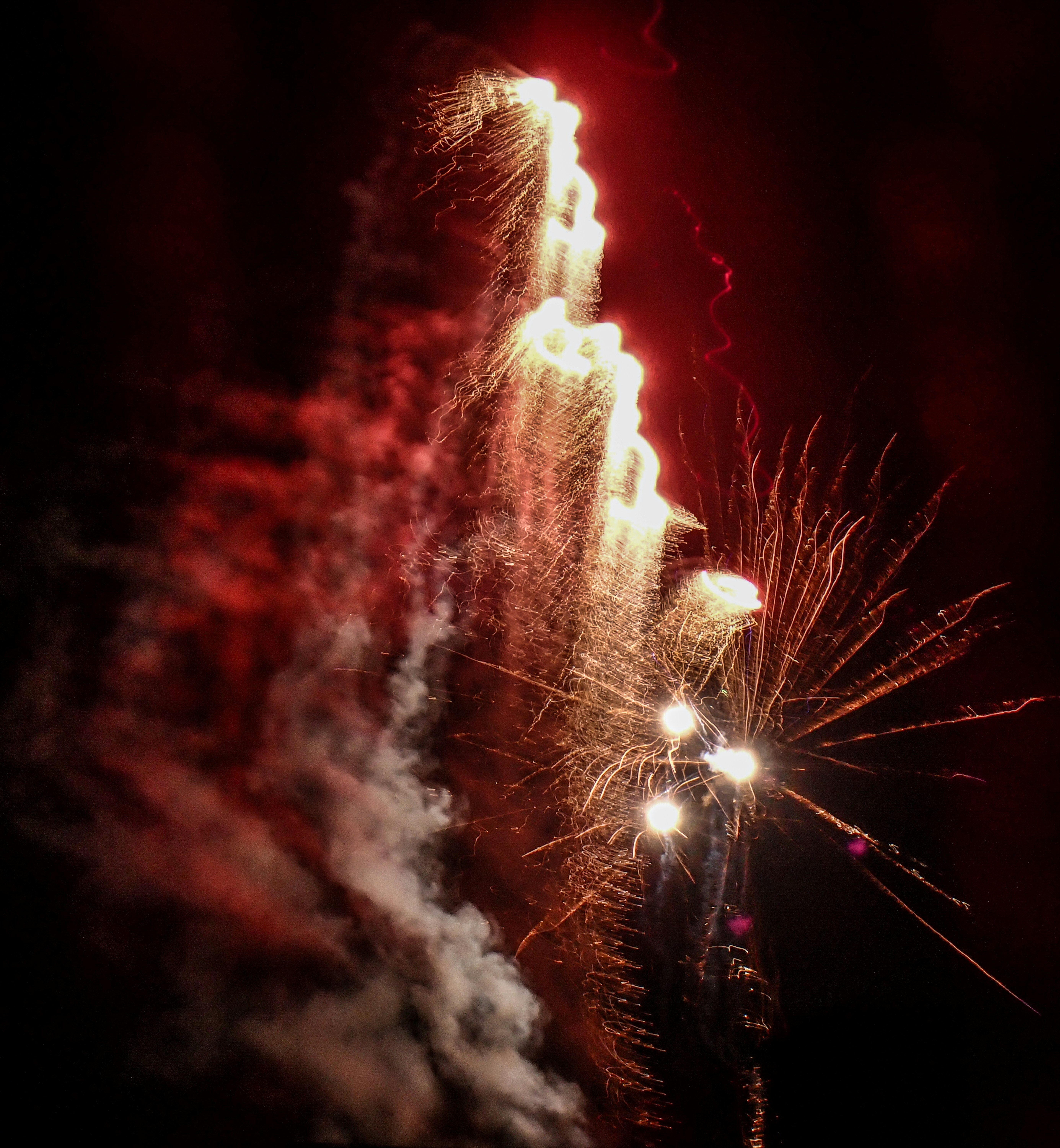 Bright fireworks explode against a dark night sky.