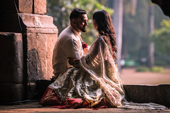 Couple embracing in ornate stone structure with greenery