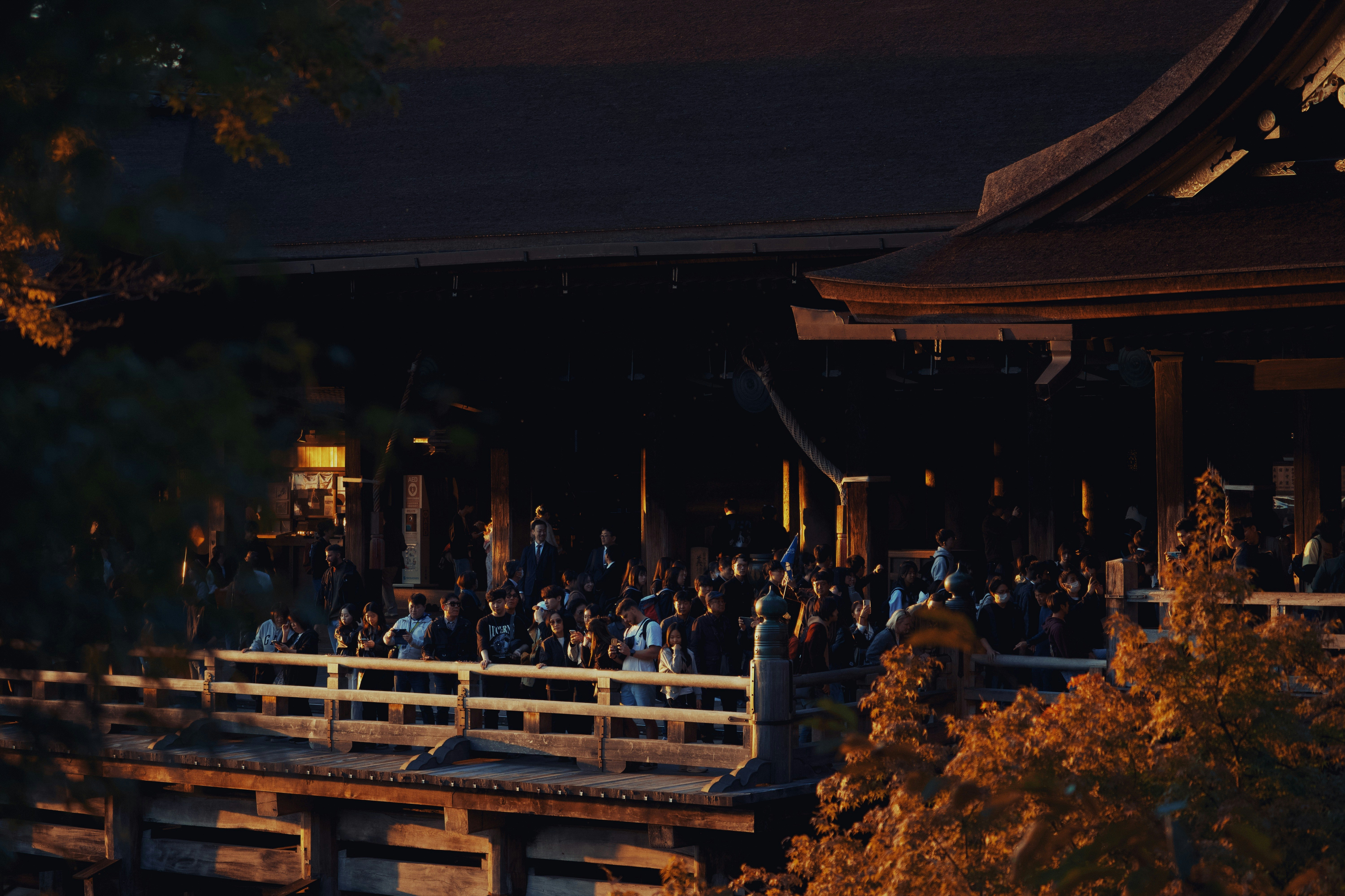 Crowd gathered on a wooden balcony of a temple