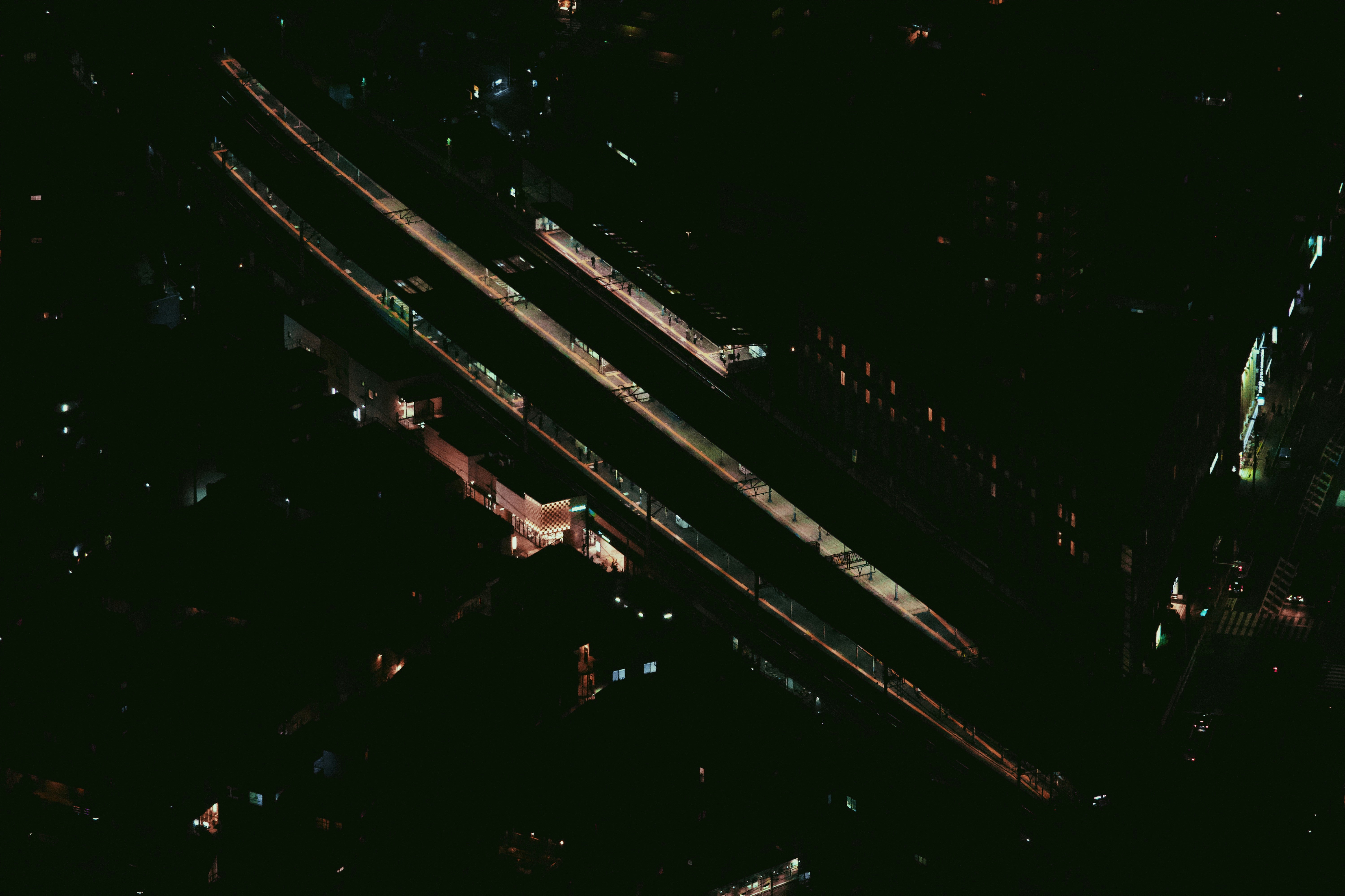 एक हवाई दृश्य जिसमें एक बड़े औद्योगिक क्षेत्र को दर्शाया गया है जिसमें रेलवे ट्रैक मुख्य कारखानों और वेयरहाउसों से जुड़ते हुए दिखाई दे रहे हैं, जो कुशल माल ढुलाई नेटवर्क का प्रतीक है।