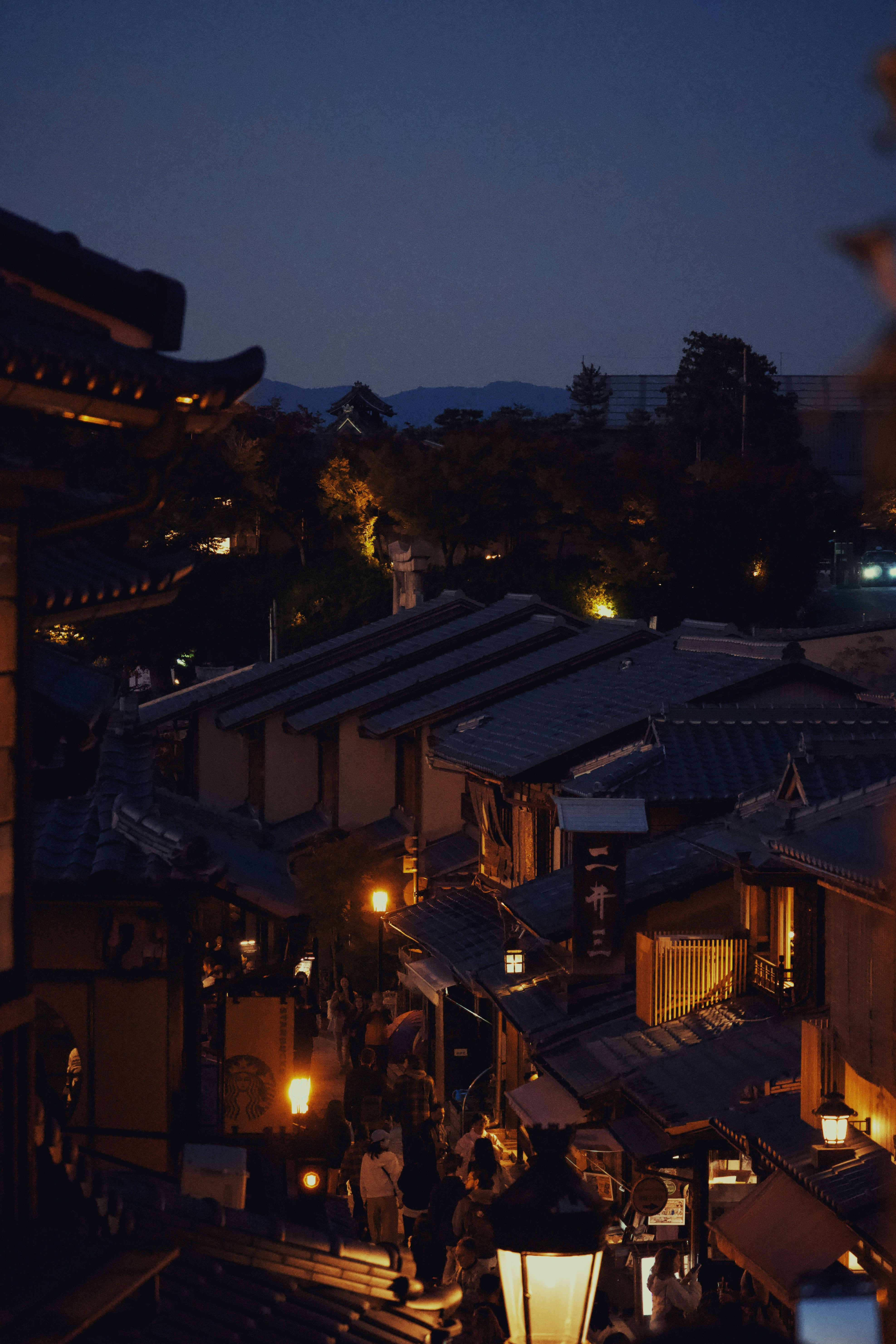 Traditional japanese street at dusk with glowing lanterns.