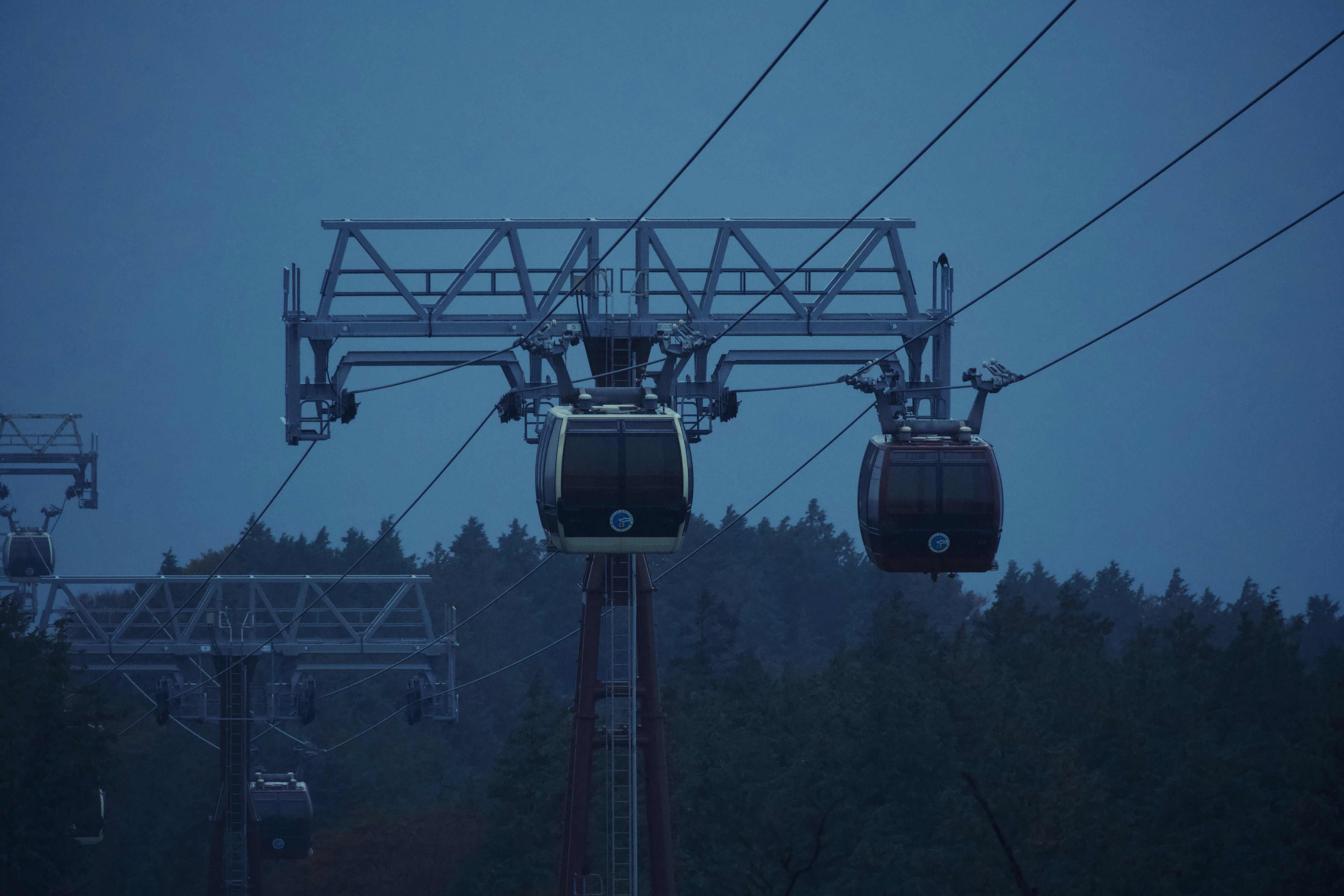 Cable cars moving through the sky at dusk