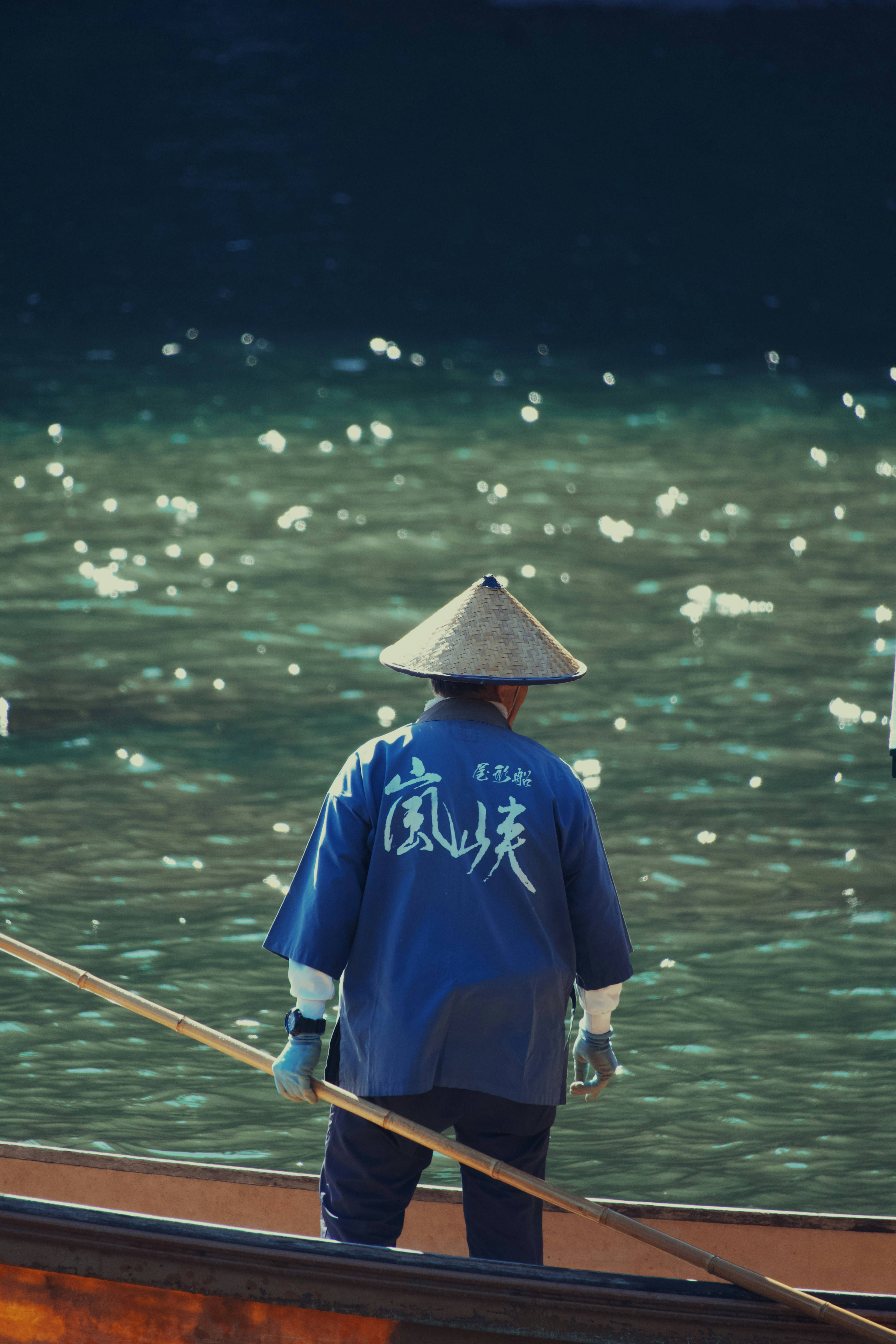 Hombre con ropa tradicional japonesa remando en un barco