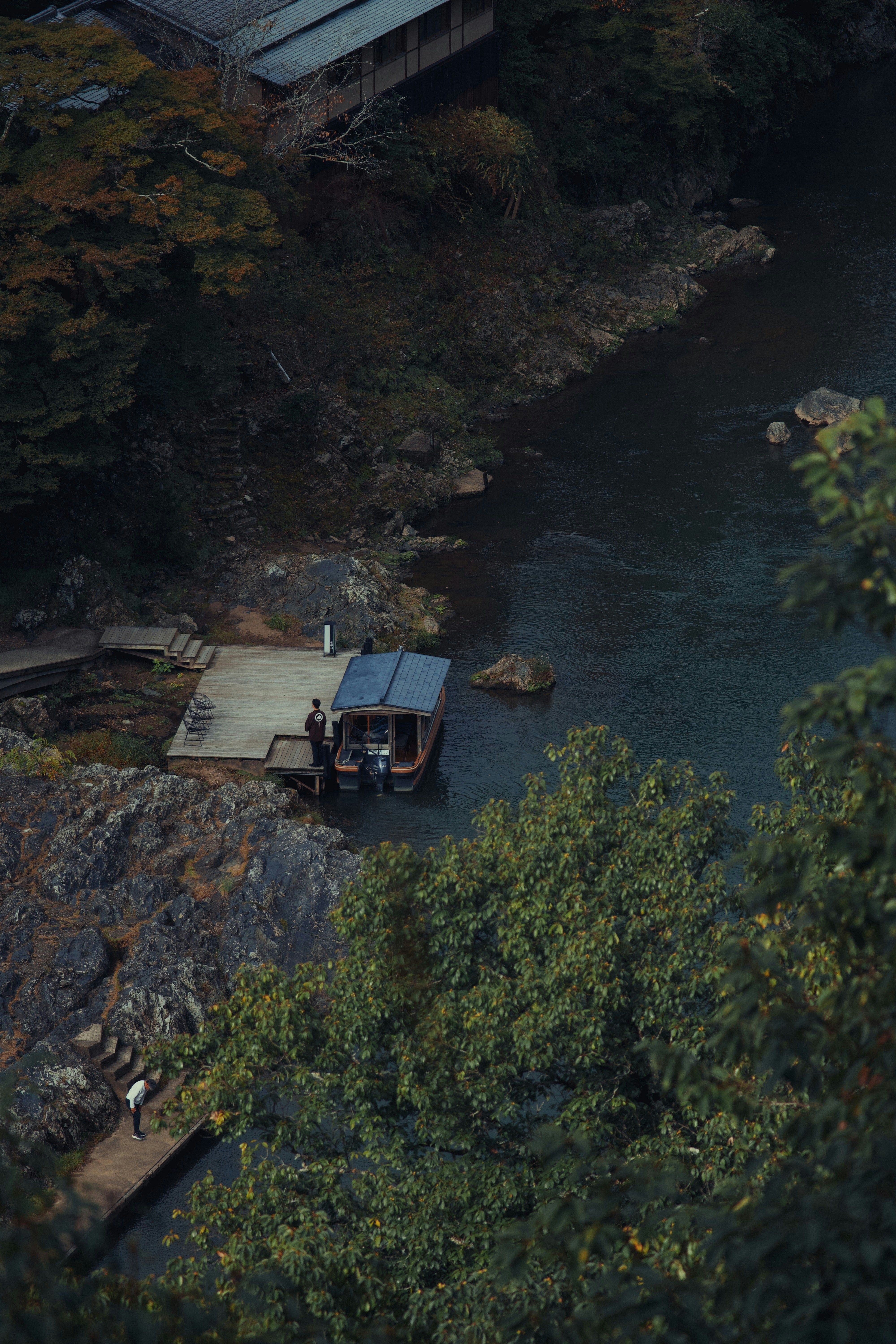 A boat docked at a pier next to a river.