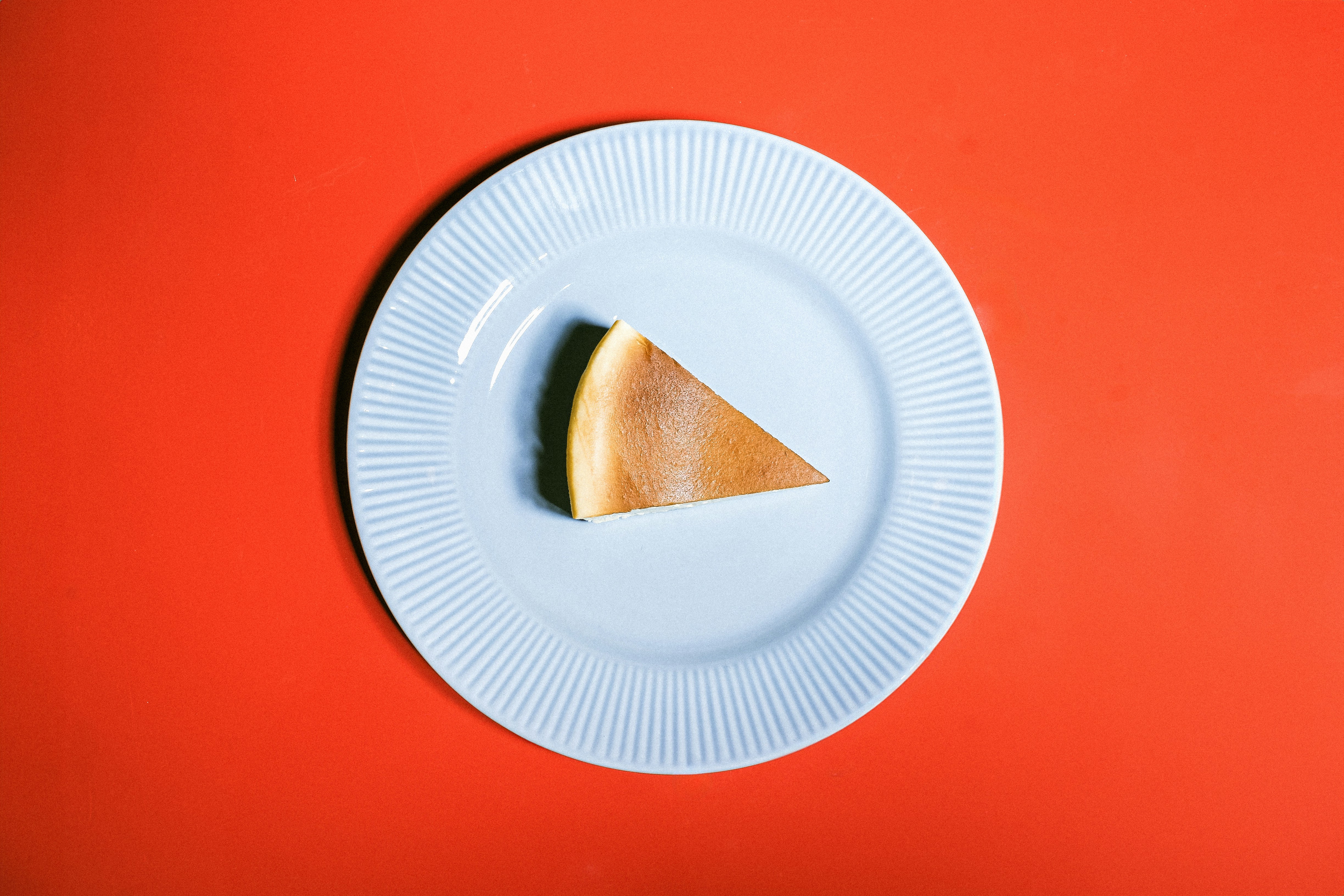 Slice of cheesecake on a blue plate.