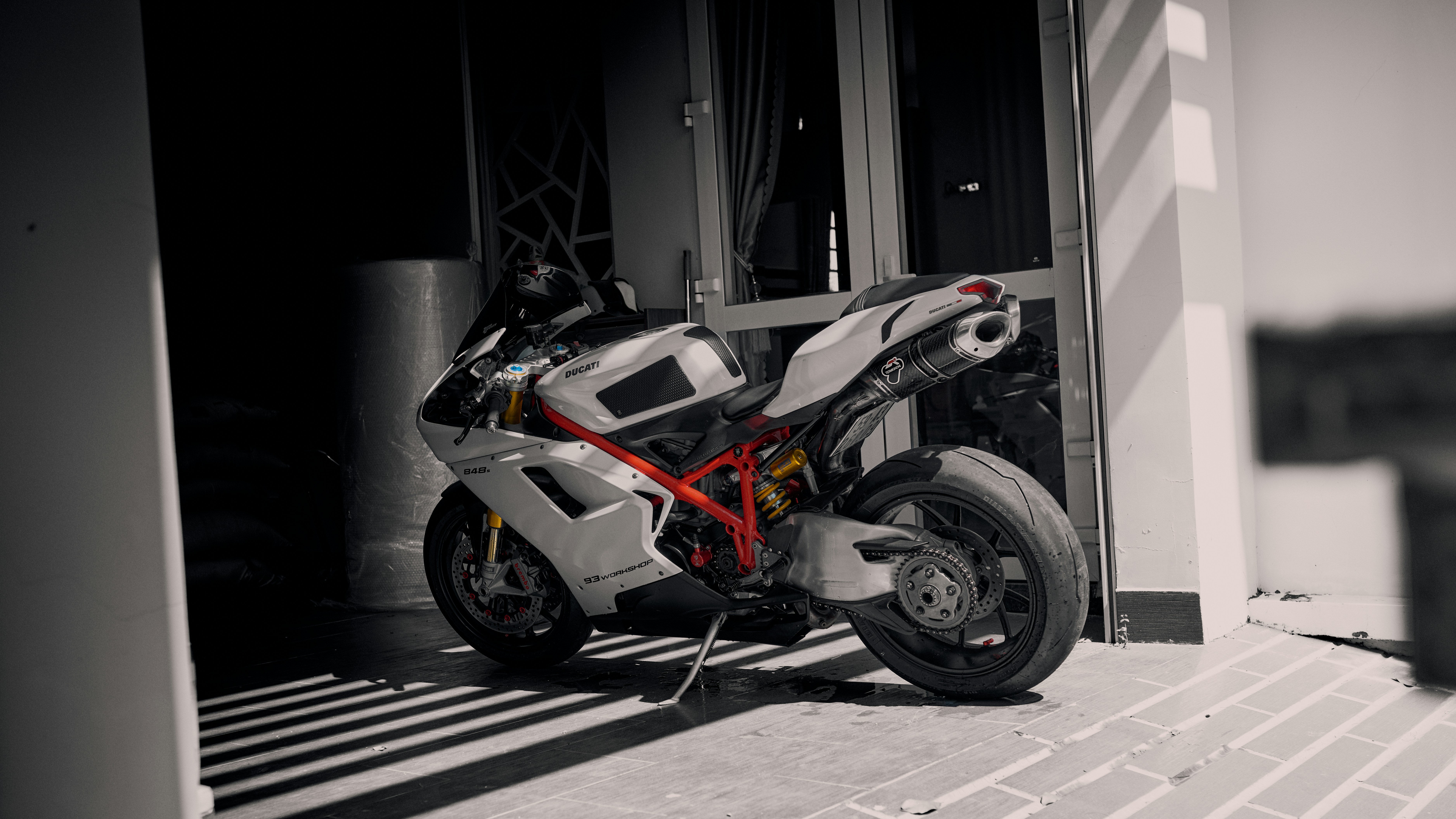 A white and red sport motorcycle parked outside.