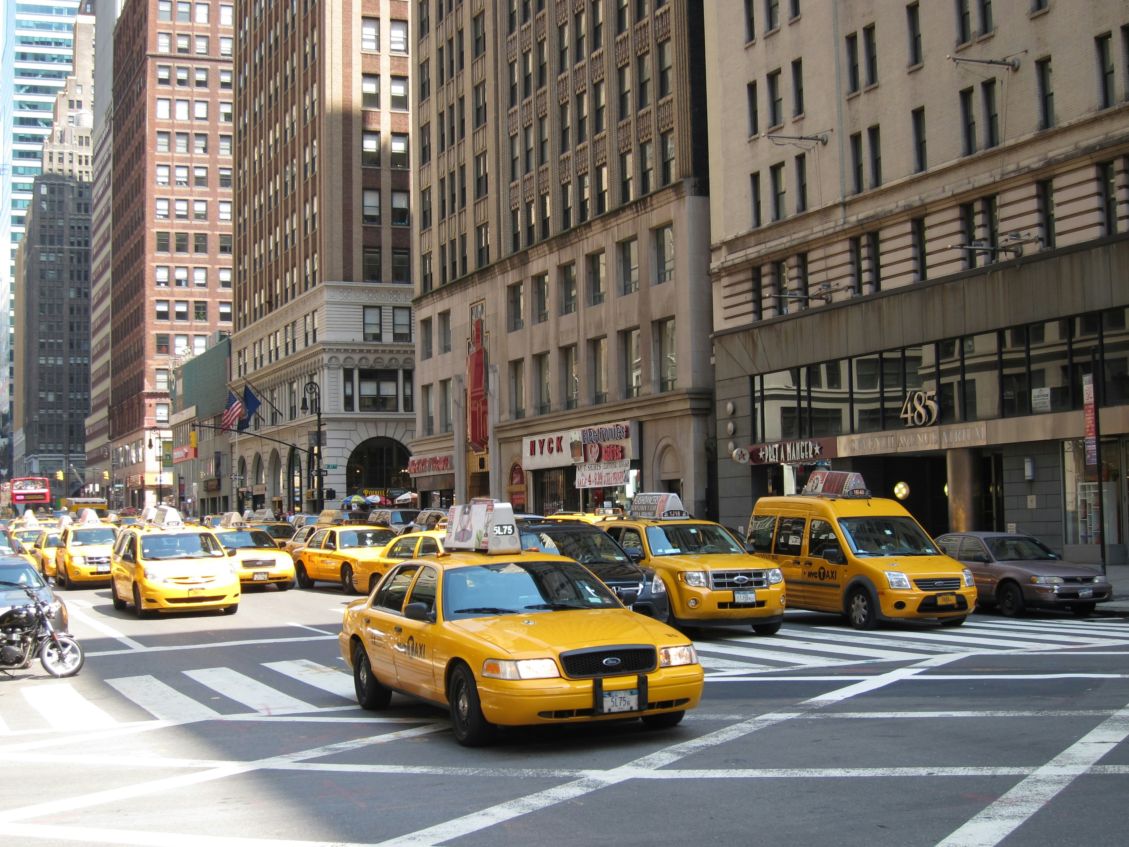 Yellow taxis driving on a city street.