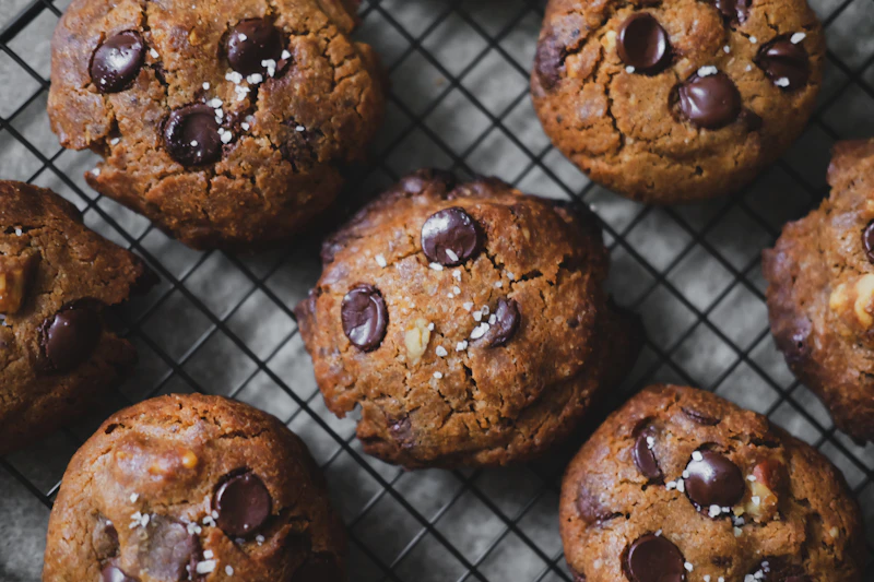 Chocolate chip cookies with flaky sea salt cooling on a wire rack
