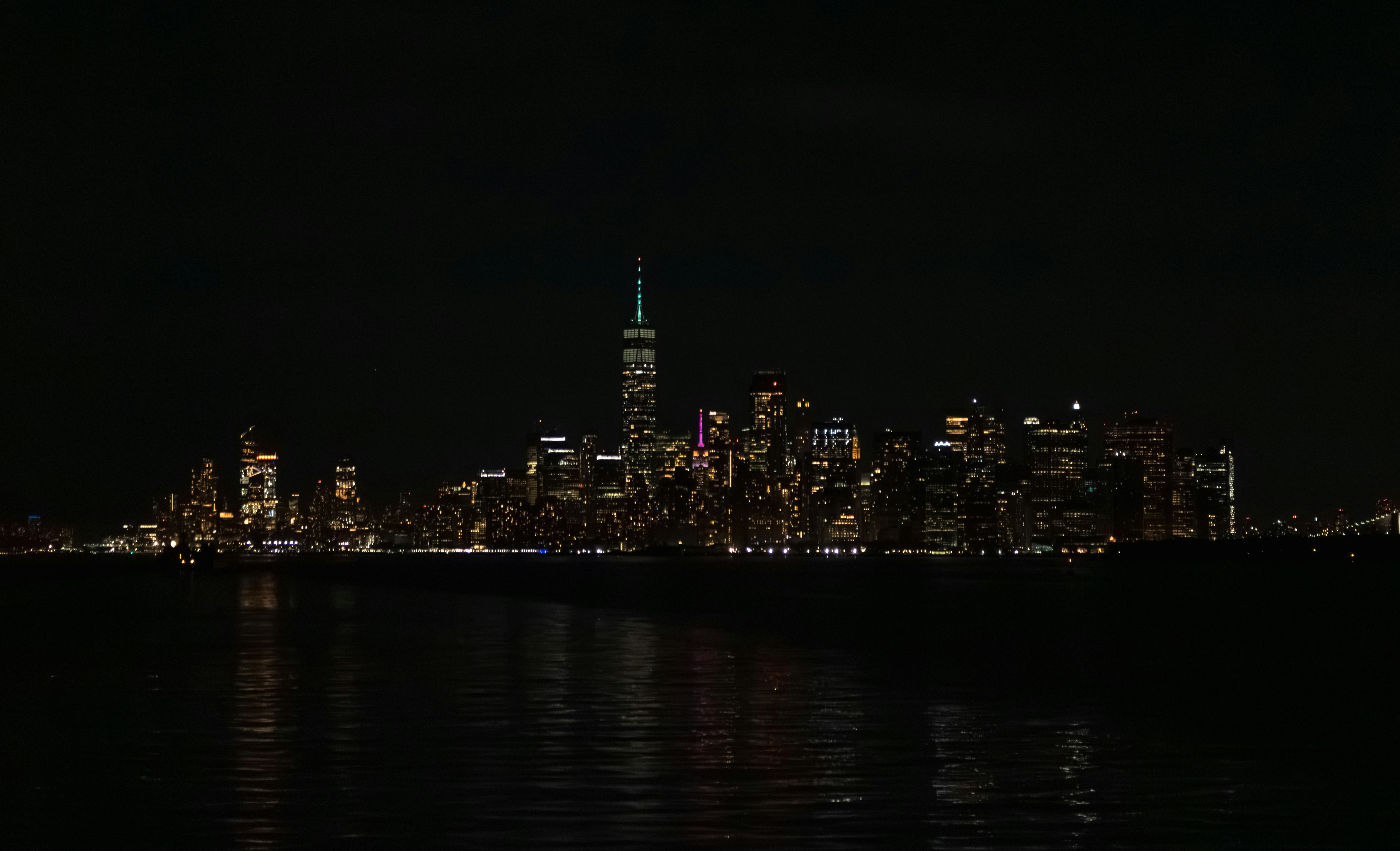 New York City skyline at night with illuminated buildings and city lights