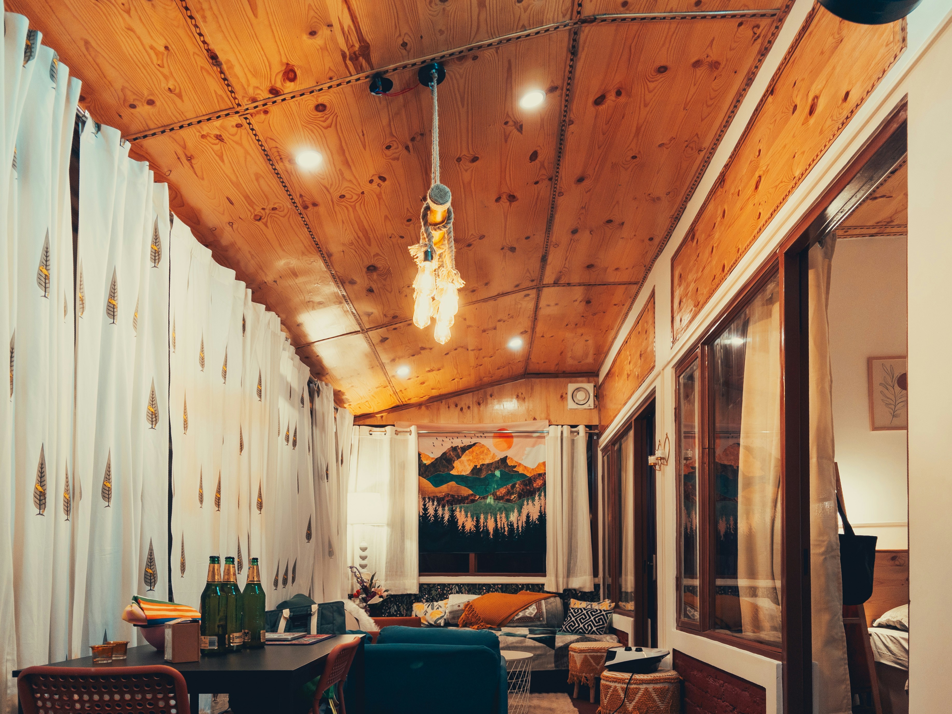 Cozy wooden porch with seating and decorative curtains