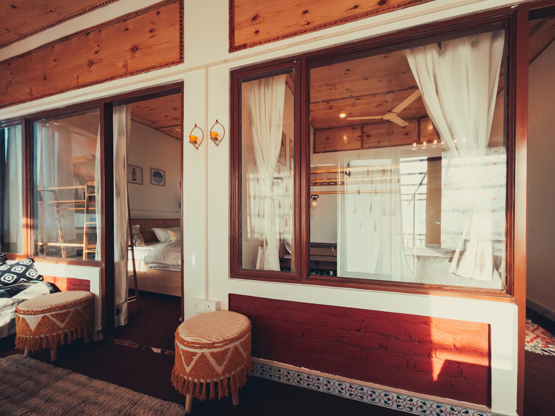 A cosy room with wooden walls, shuttered windows and soft light