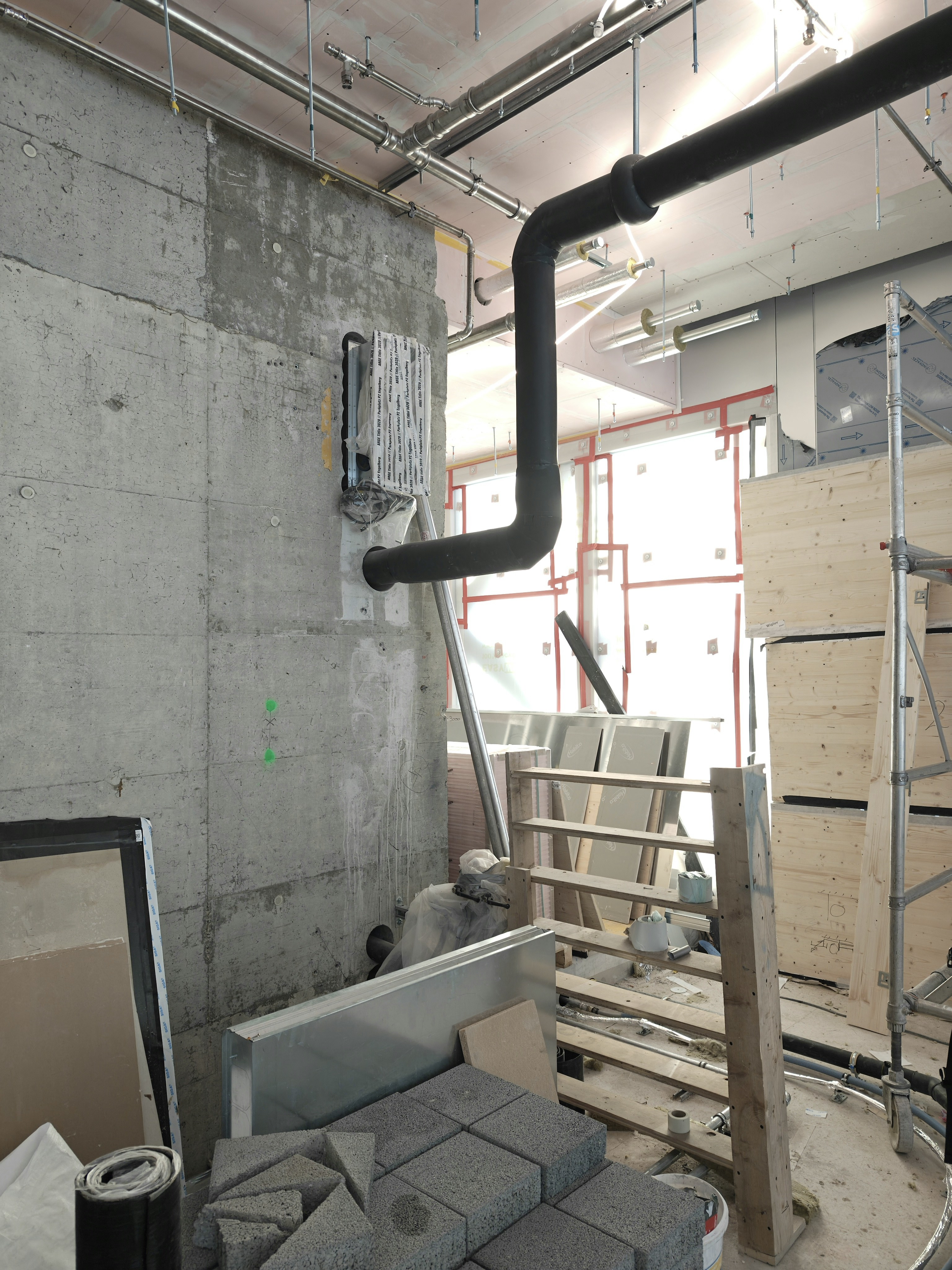 Industrial interior with pipes and construction materials.