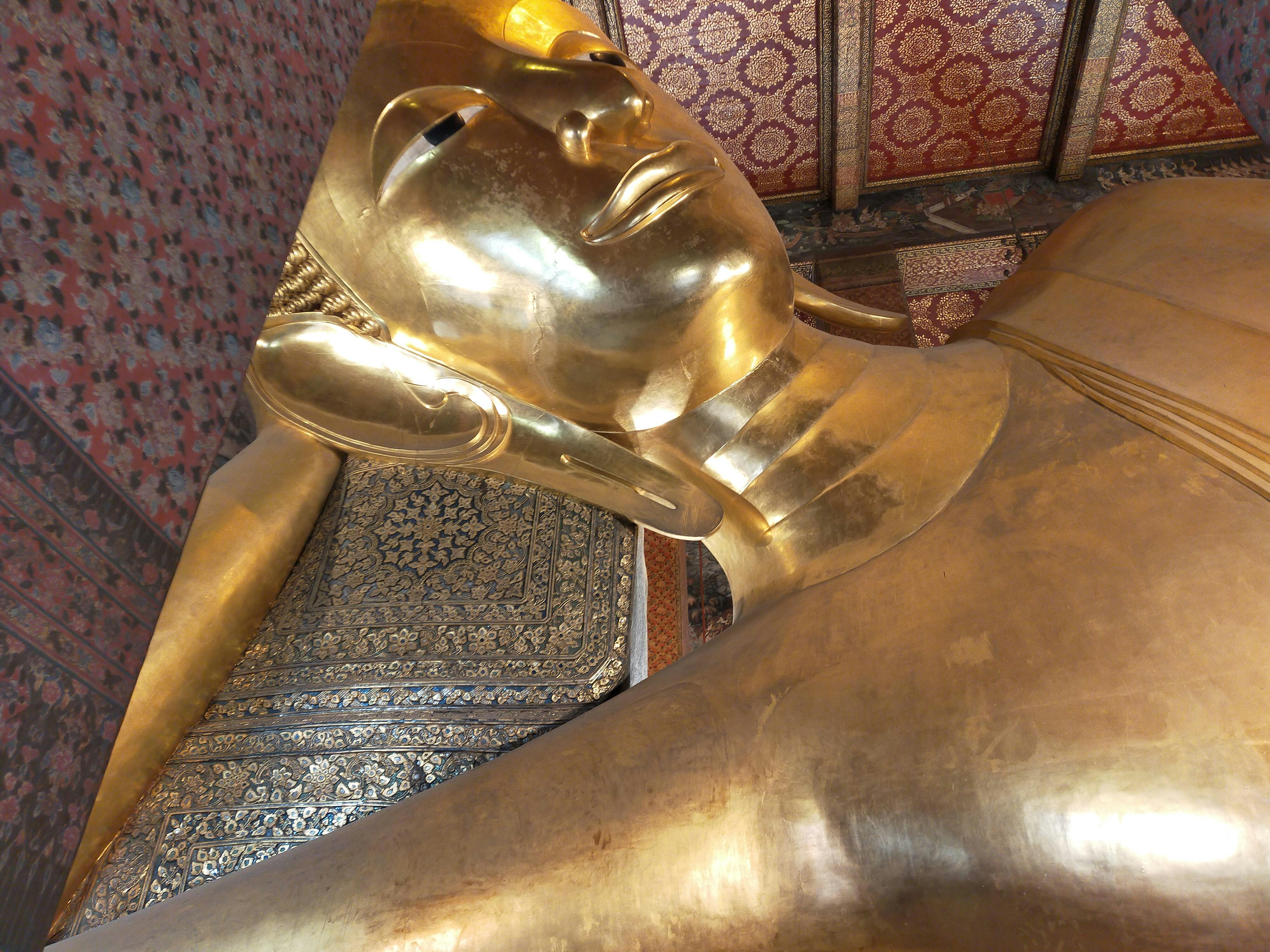 Reclining golden buddha statue with intricate details.