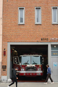 Fire truck parked in a fire station entrance.