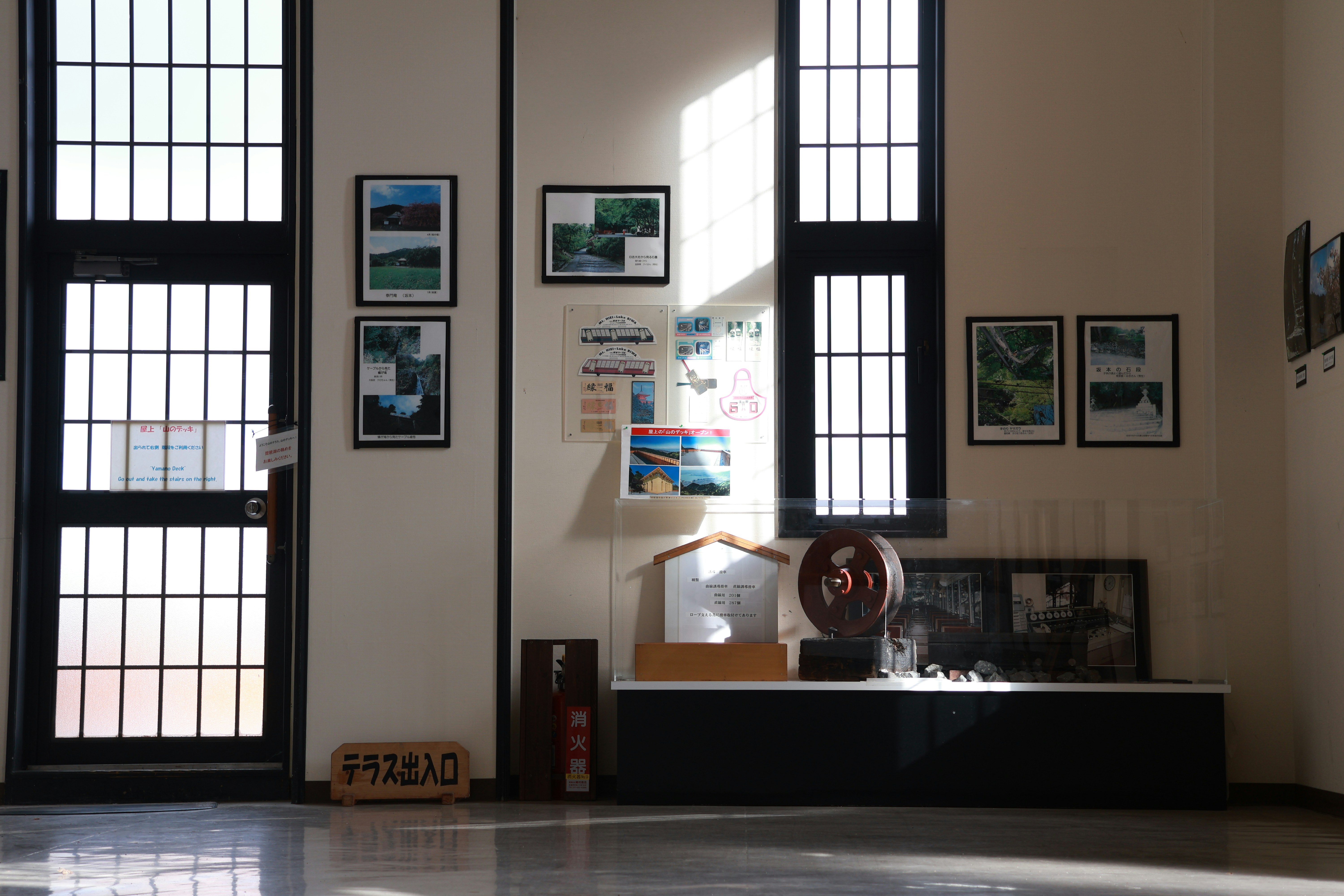 Sunlight streams through large windows in a gallery.