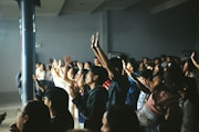 A crowd of people with hands raised in excitement.
