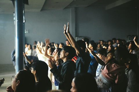 A crowd of people with hands raised in excitement.
