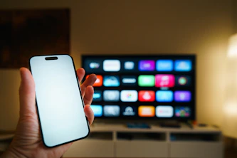 Smartphone held in front of a smart TV screen