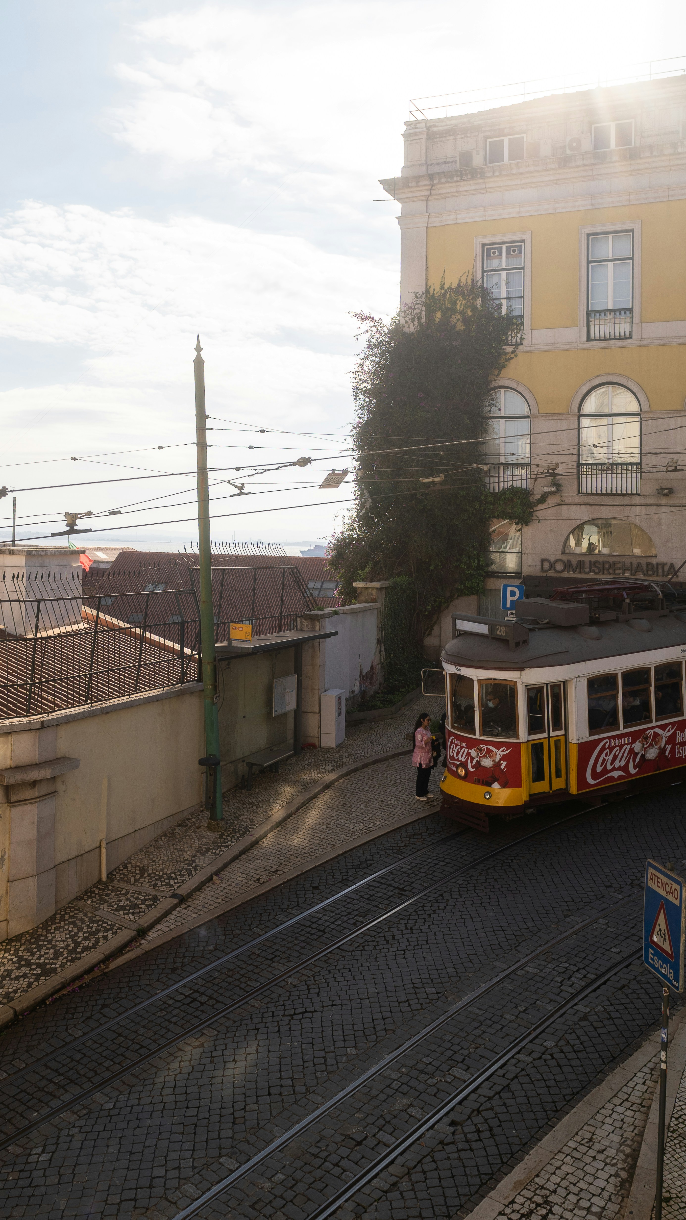 A vintage tram on cobblestone street with building.