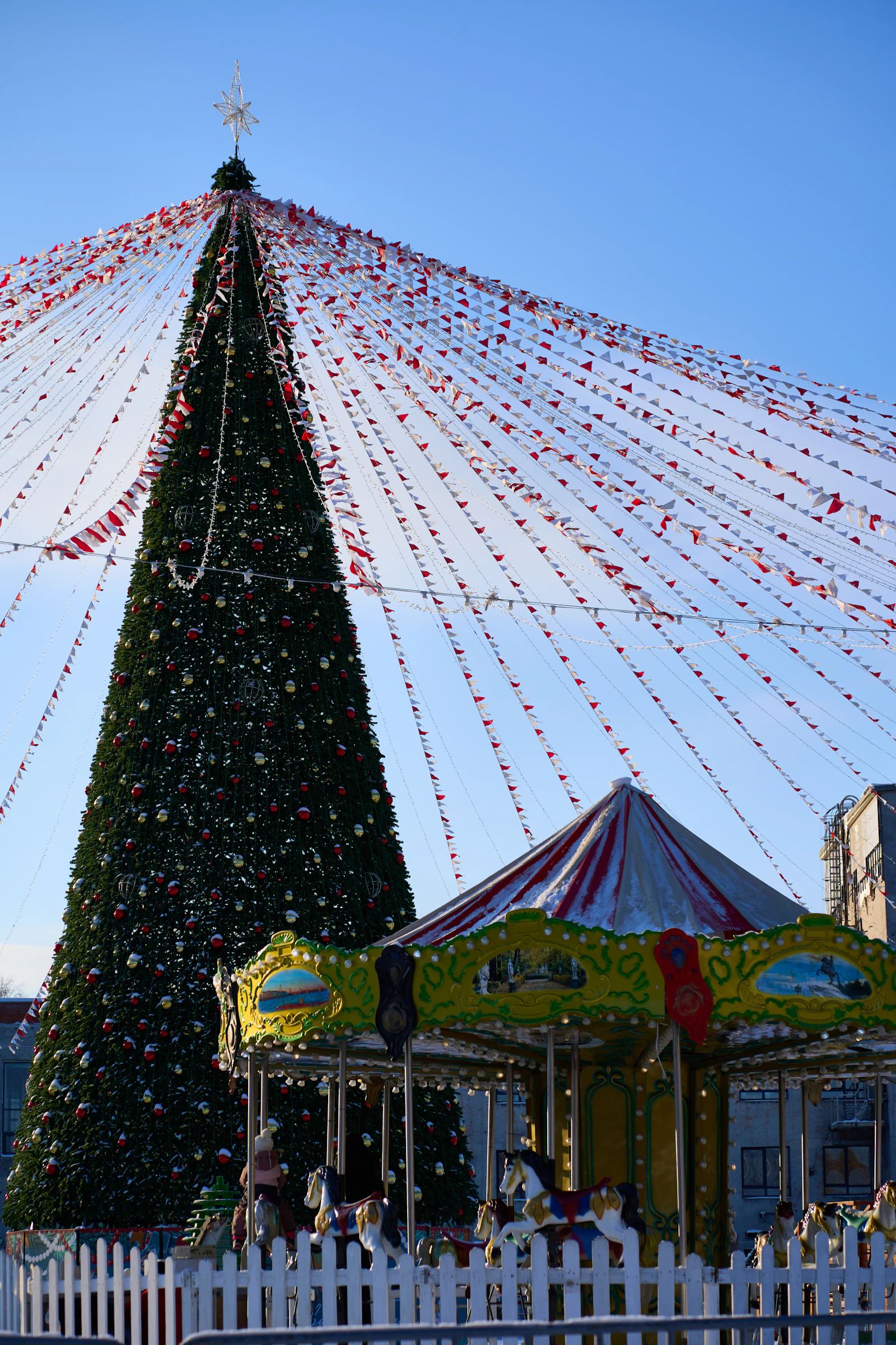 Kerstboom en draaimolen onder feestelijke versiering
