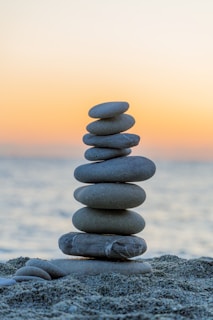 Stack of stones on beach at sunset
