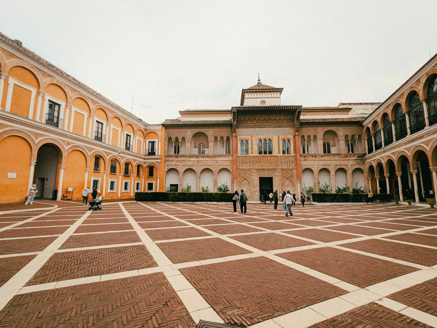 Travelers cross the arcaded courtyard of Seville's Royal Alcazar on a Spain and Morocco journey