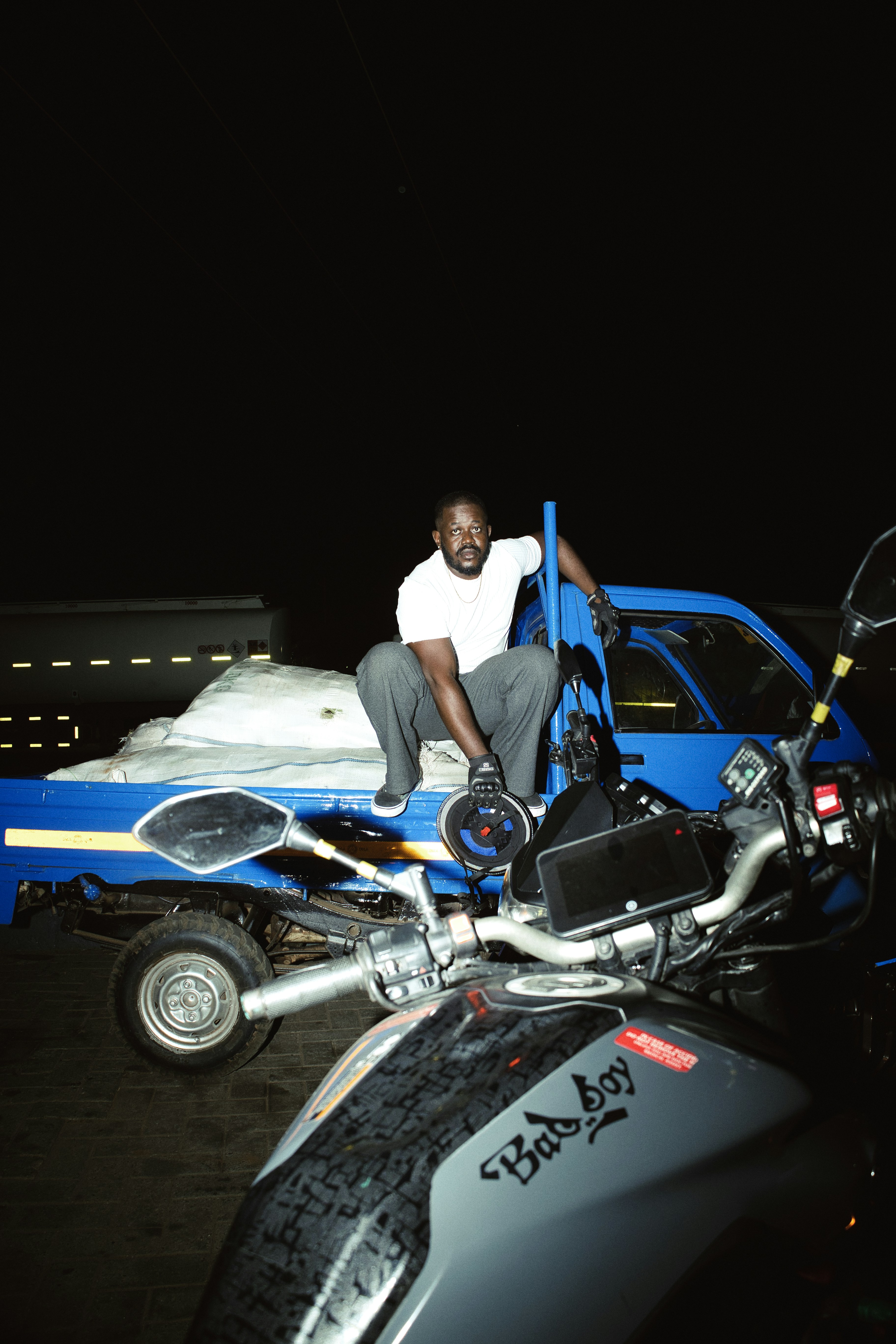Man sitting on a truck with motorcycles nearby motorcycles