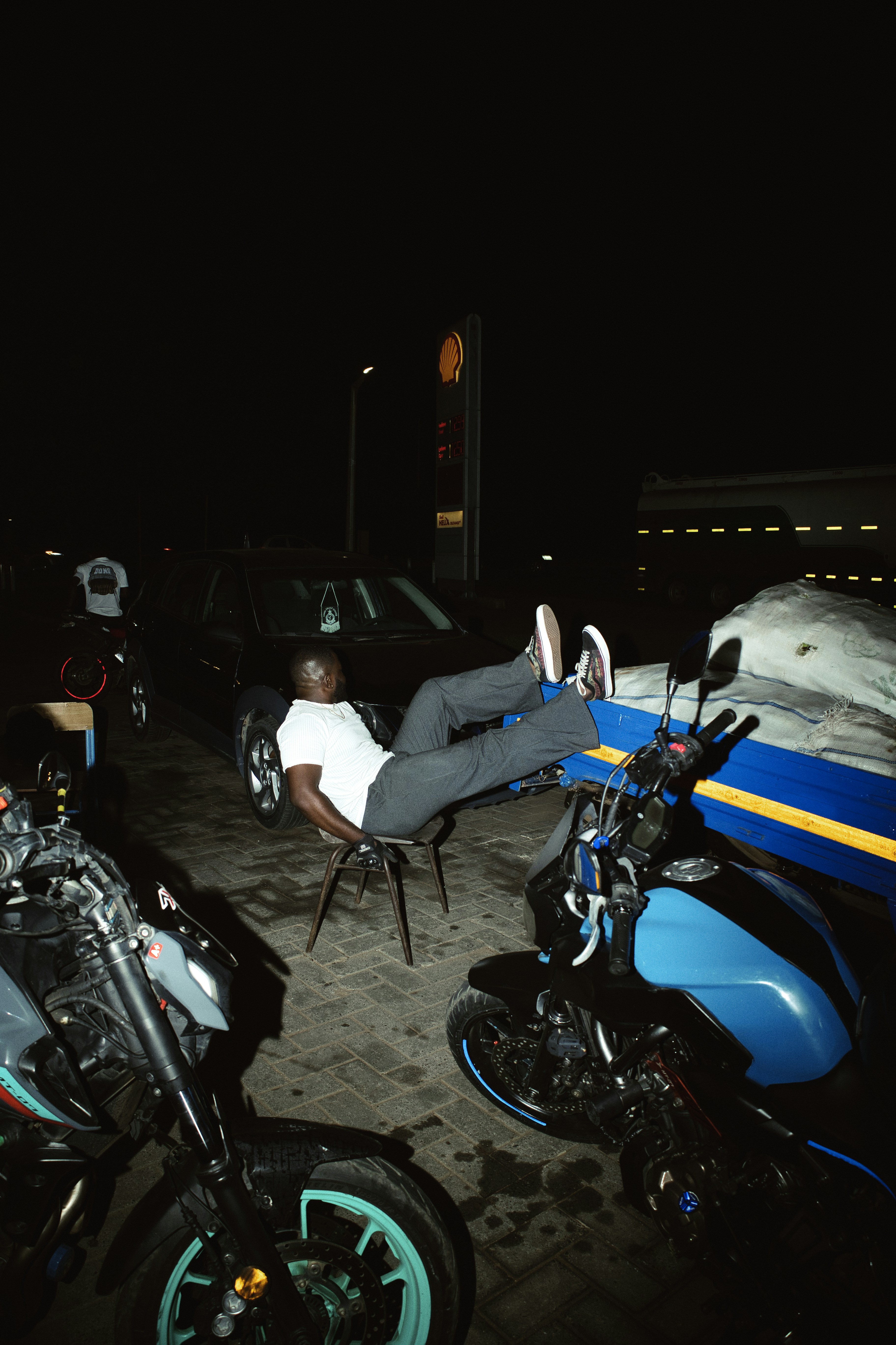 Man sitting on chair with motorcycles at night