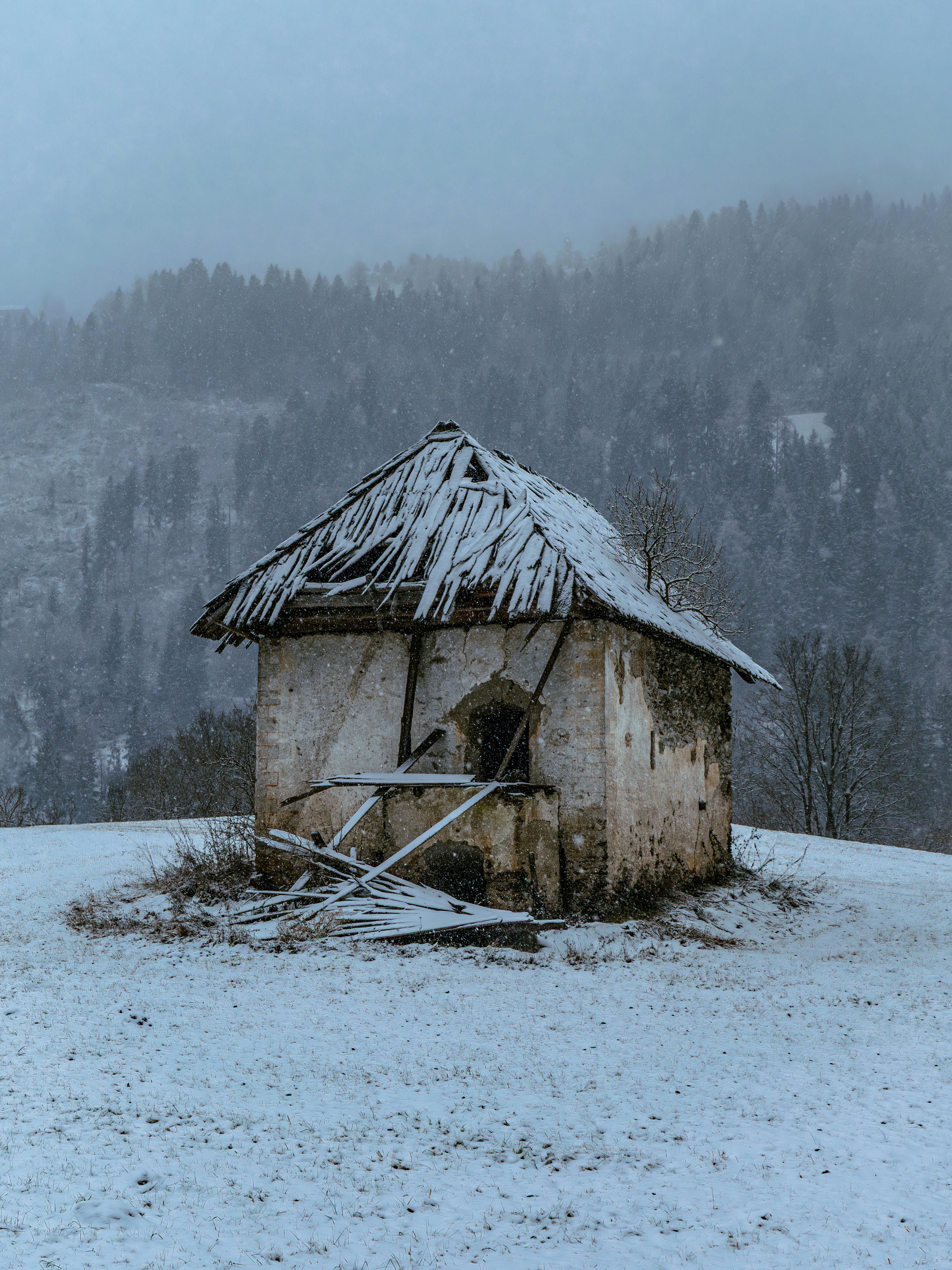 Old abandoned shack on a snowy hill