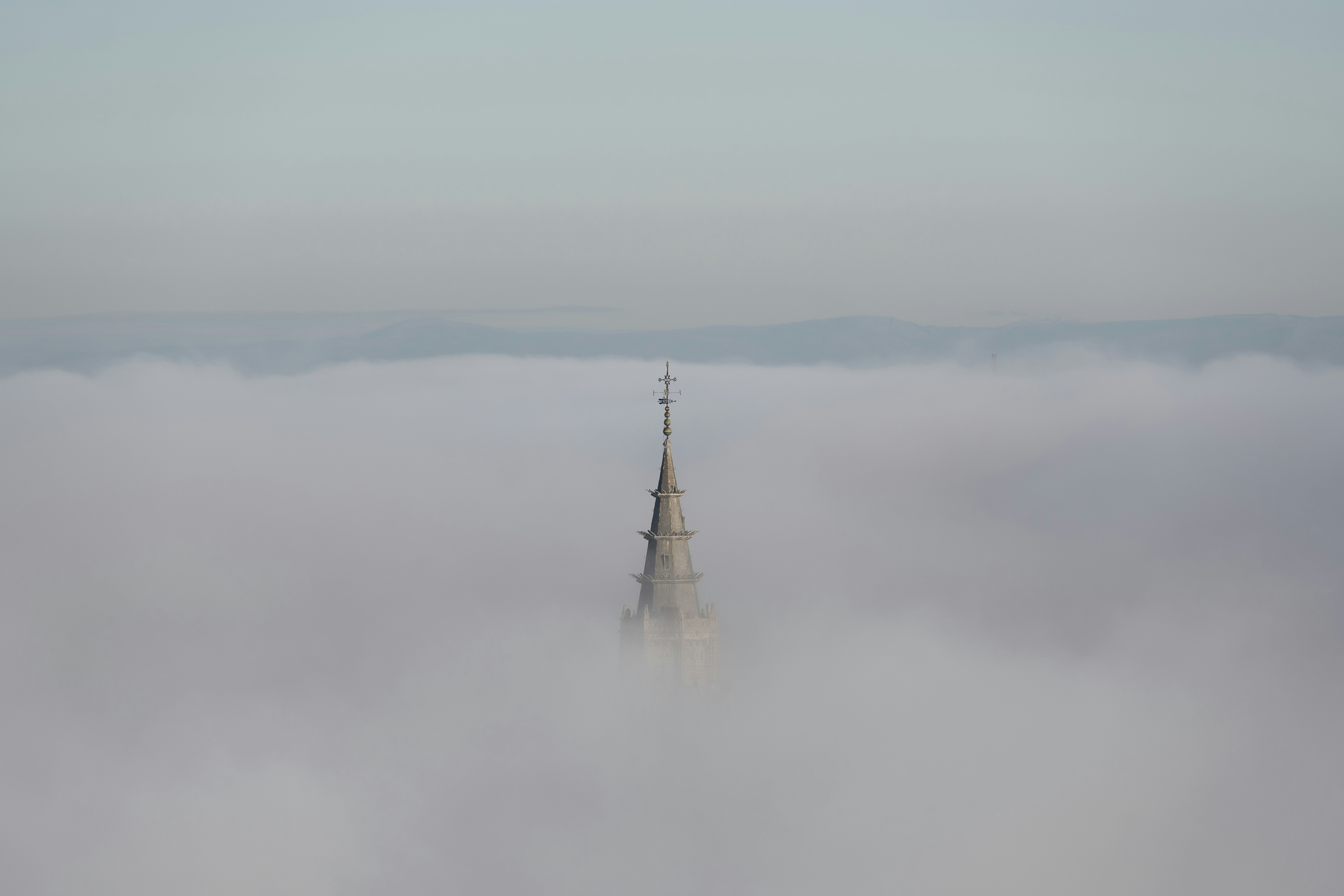 Torre da igreja emergindo de uma névoa densa