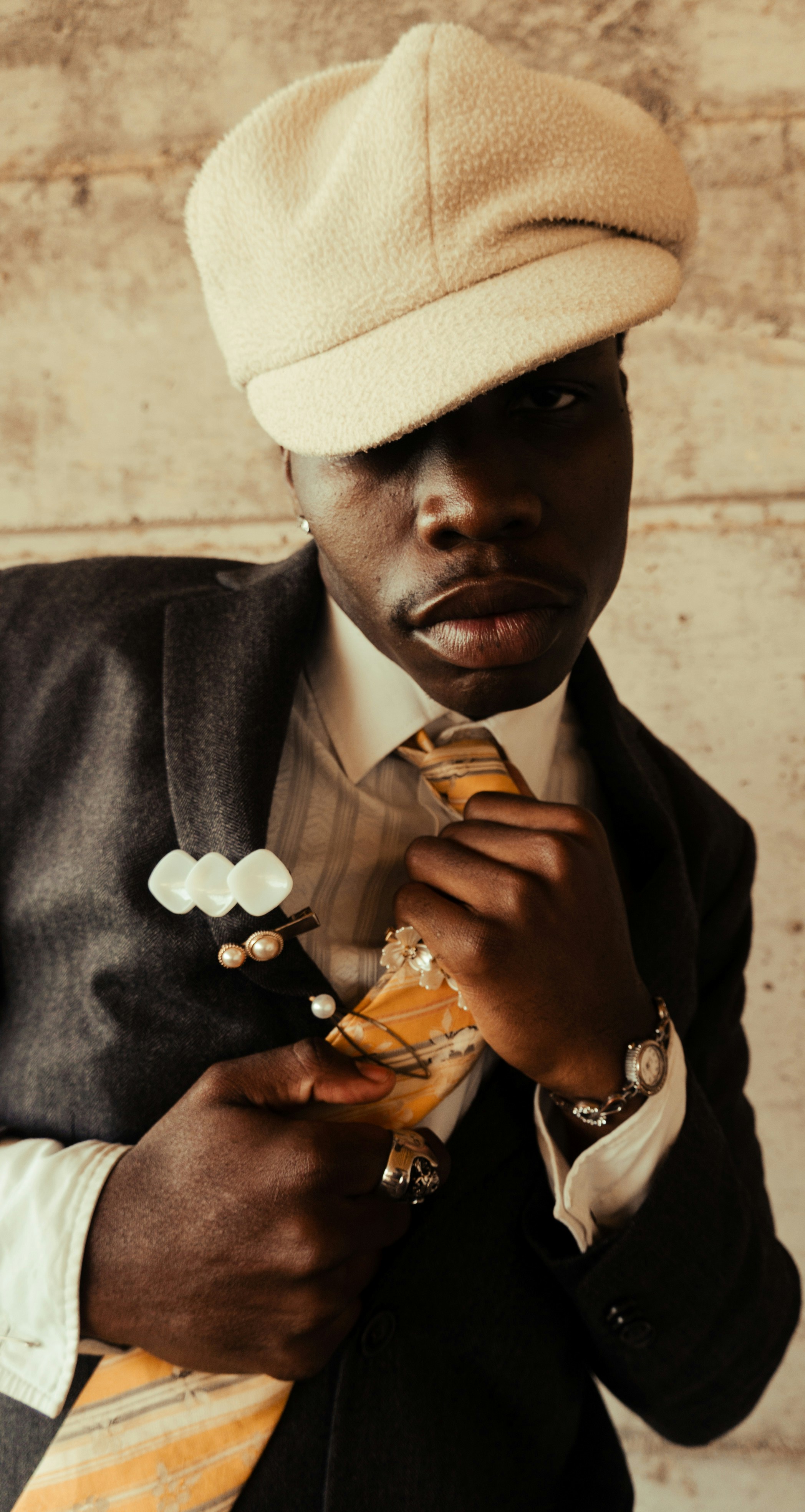 Homme en costume et casquette ajustant sa cravate