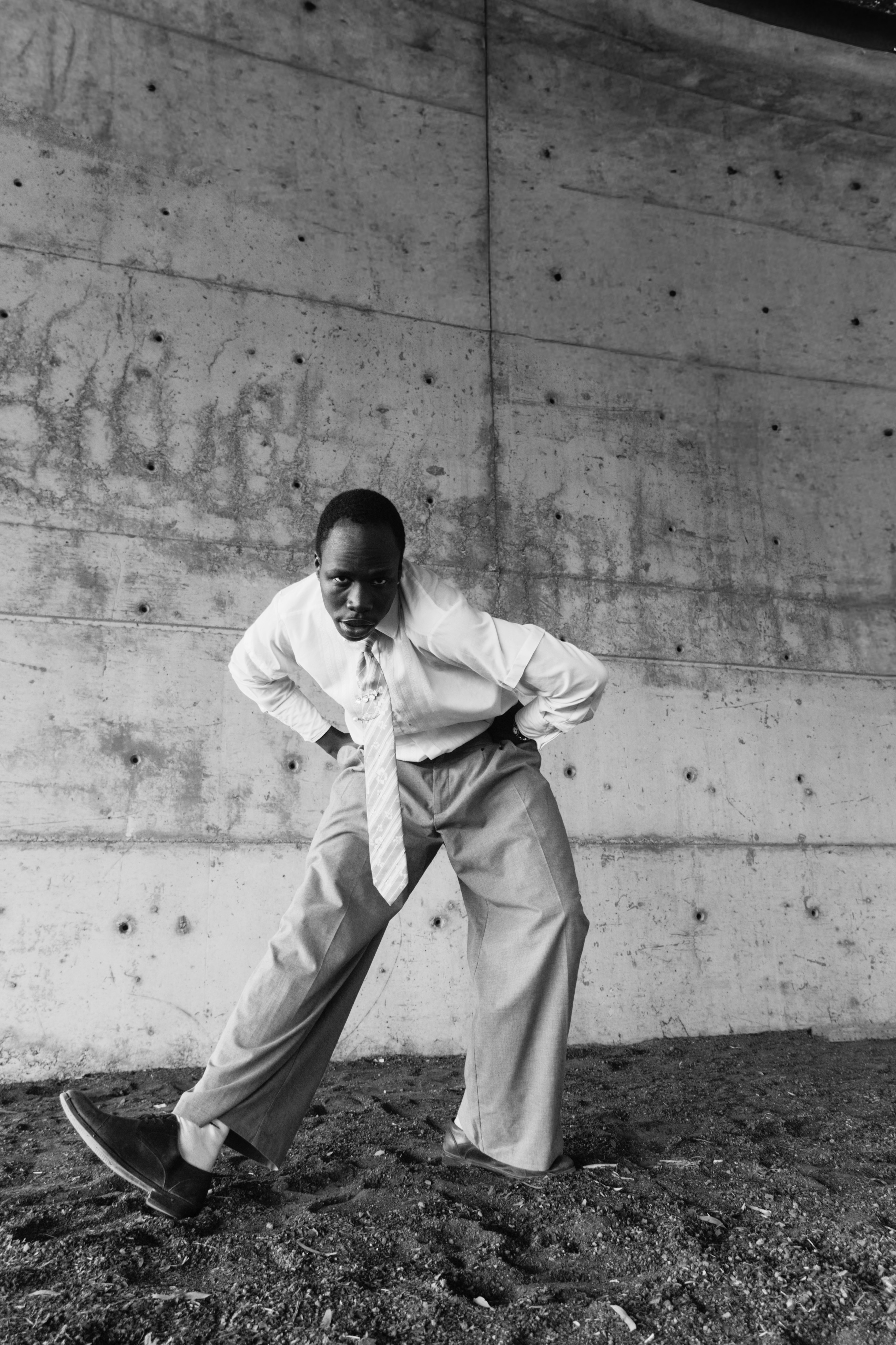 Homme en costume penché, les mains sur les hanches