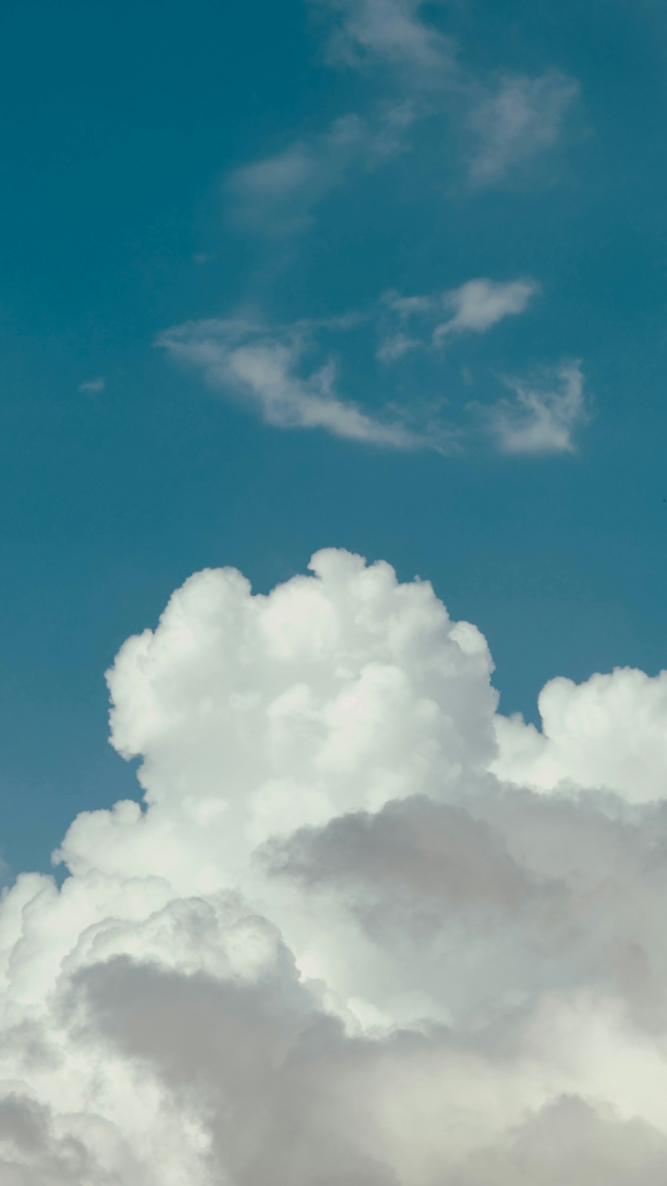 Fluffy white clouds against a bright blue sky