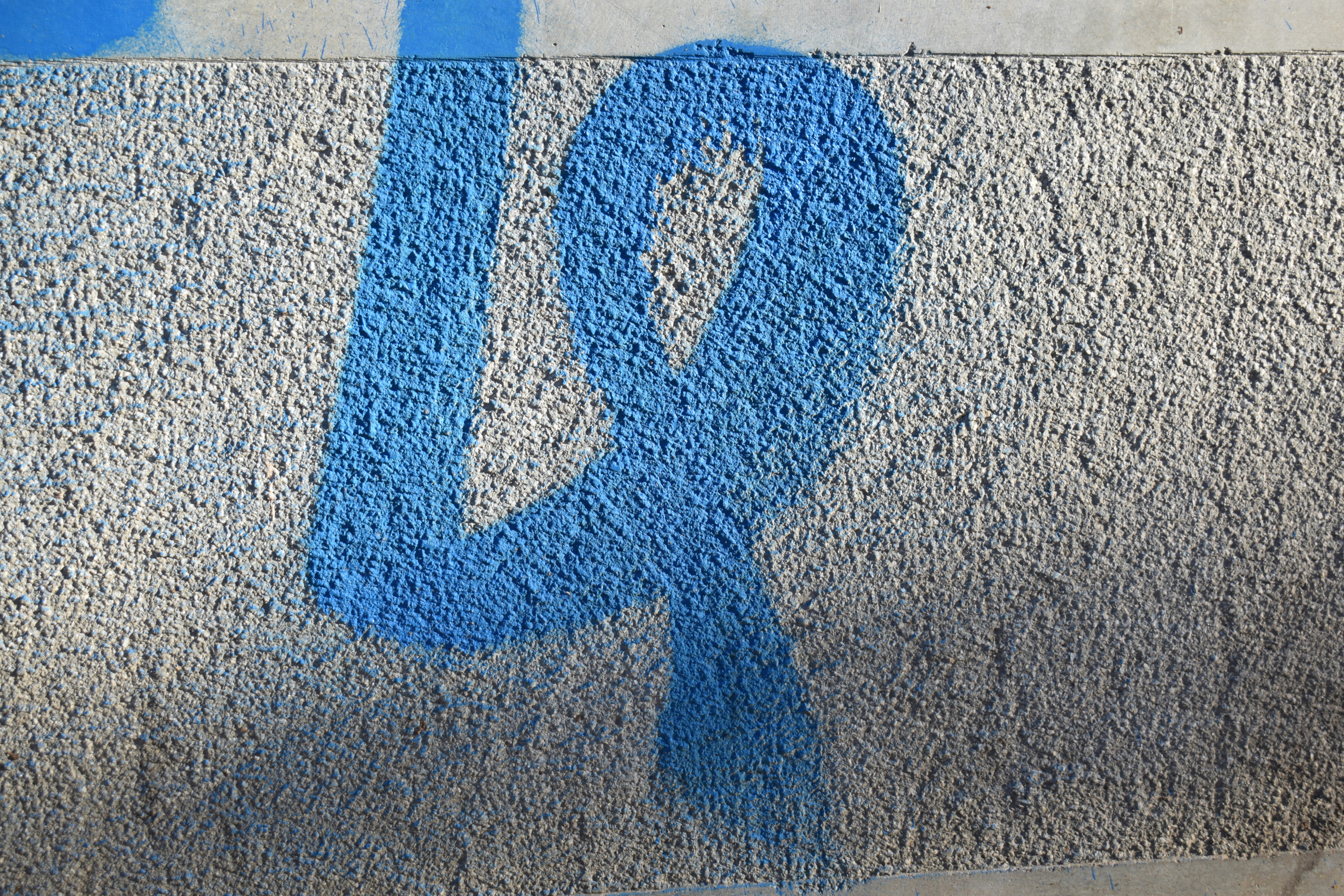 Blue spray paint number 14 on textured wall