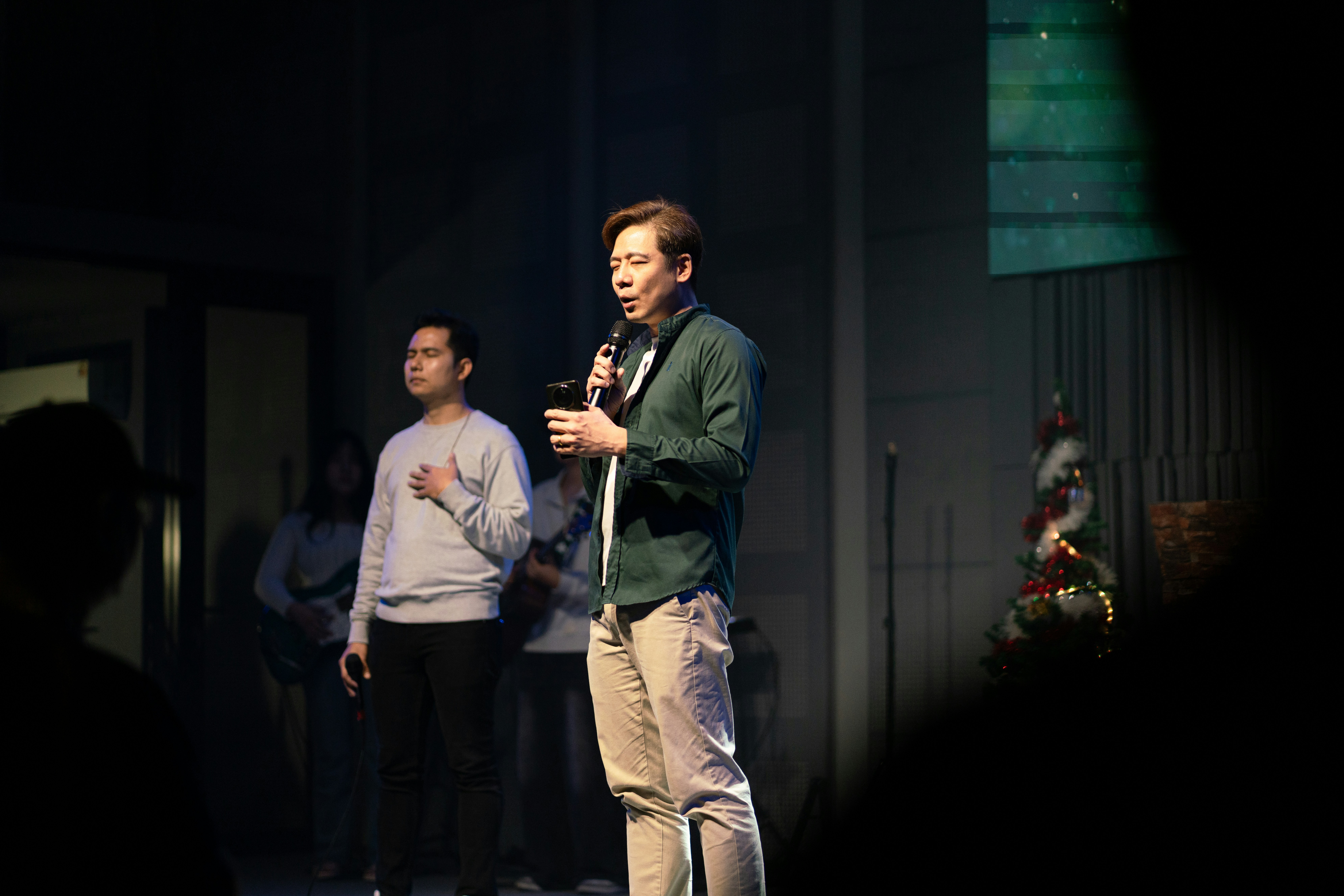 A man speaking into a microphone on stage.