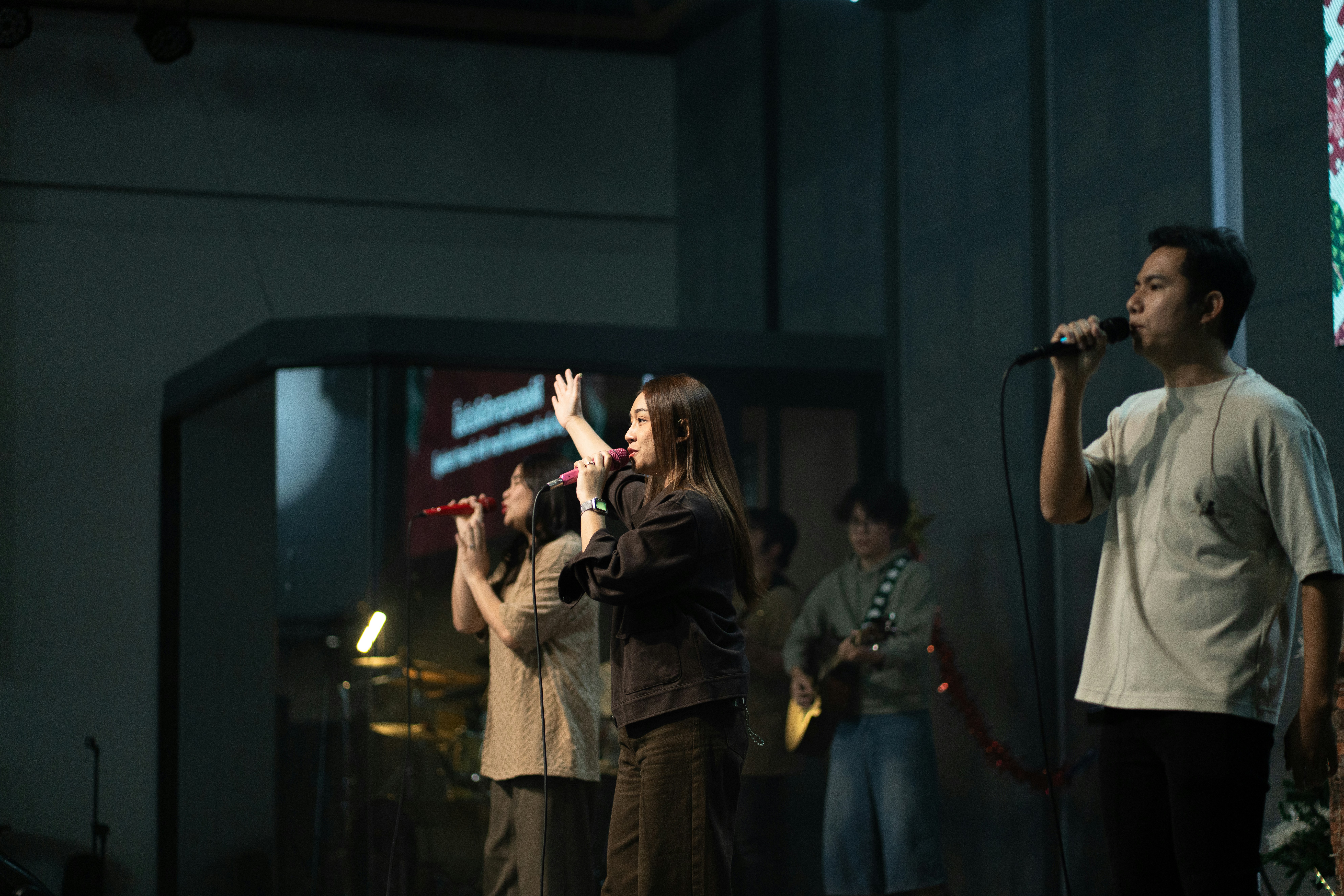 A group of people singing on a stage.