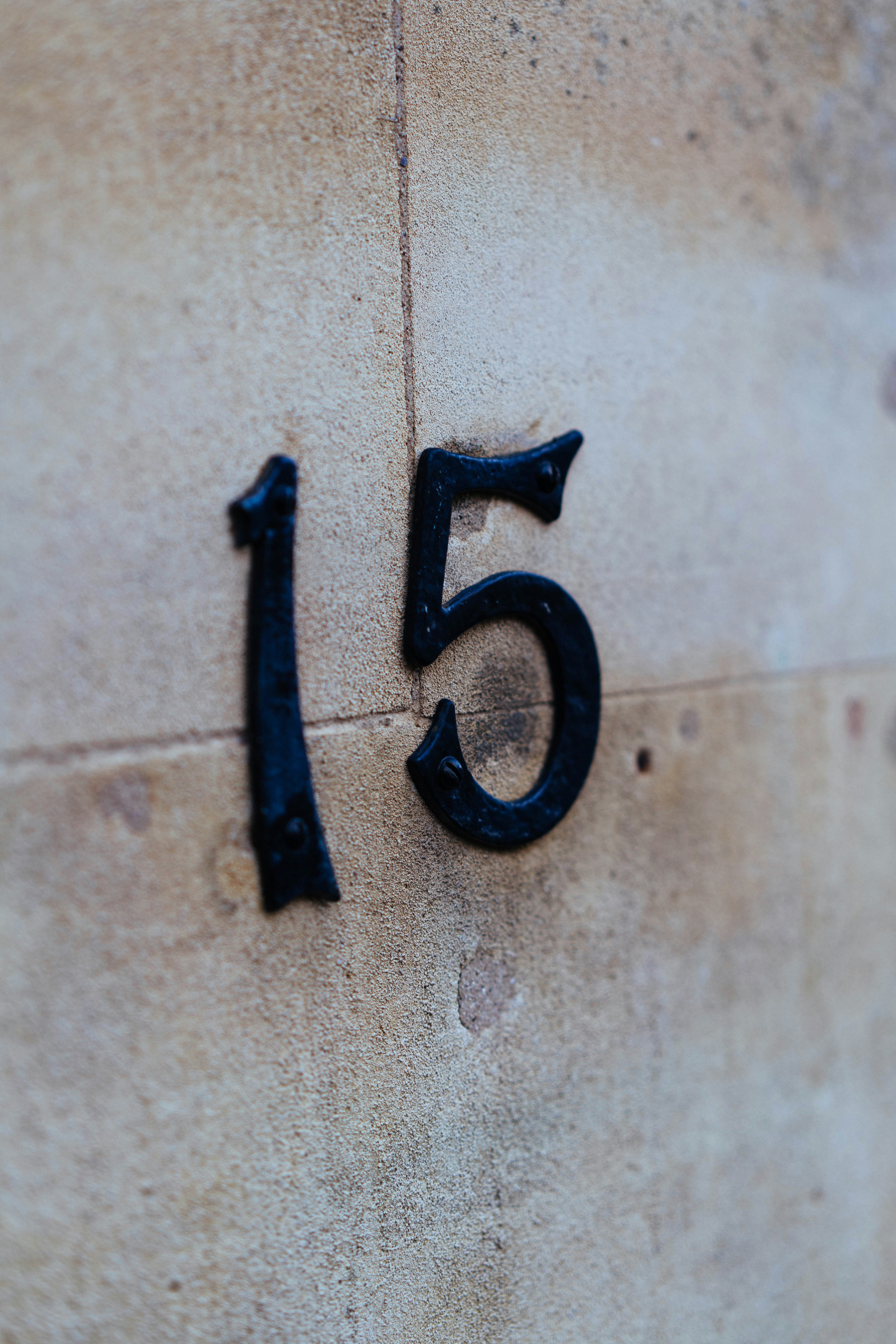 Black number 15 on a stone wall.